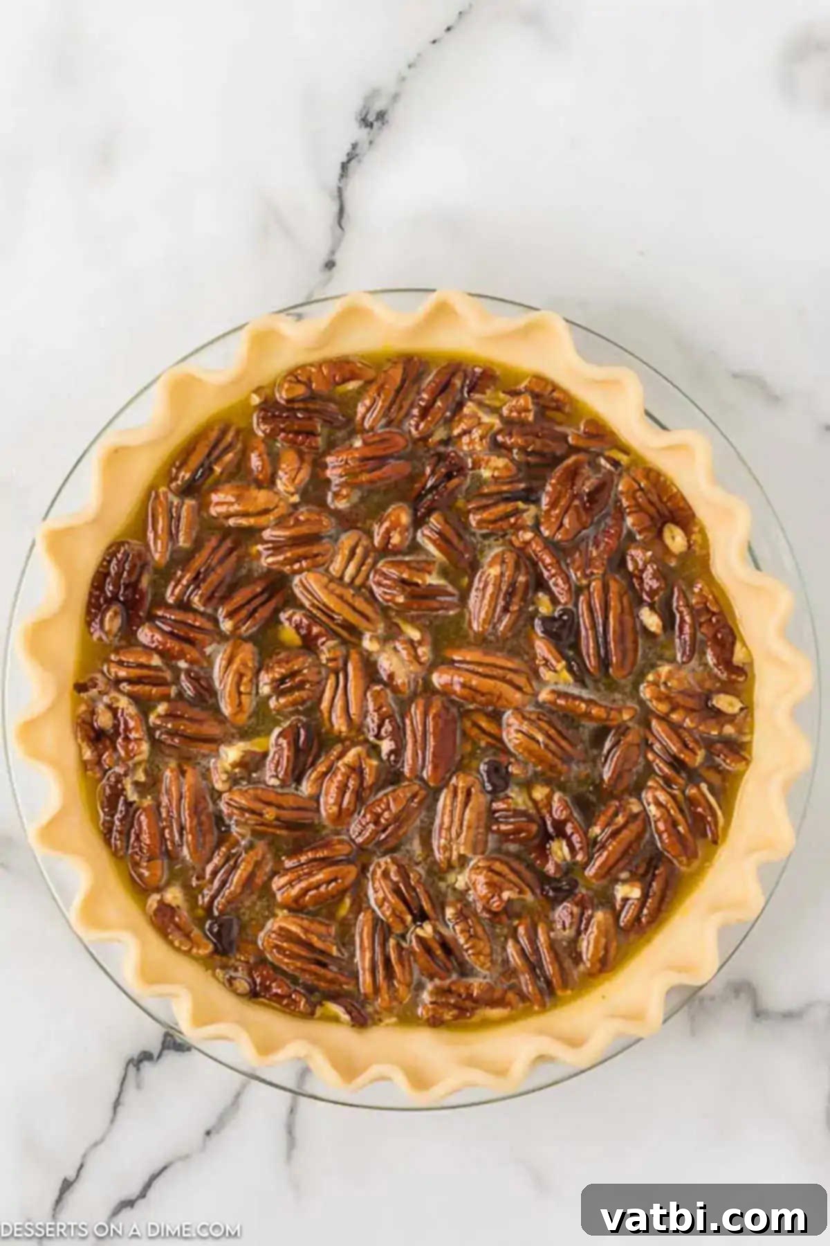 Pecan pie mixture being carefully poured into an unbaked pie crust. 