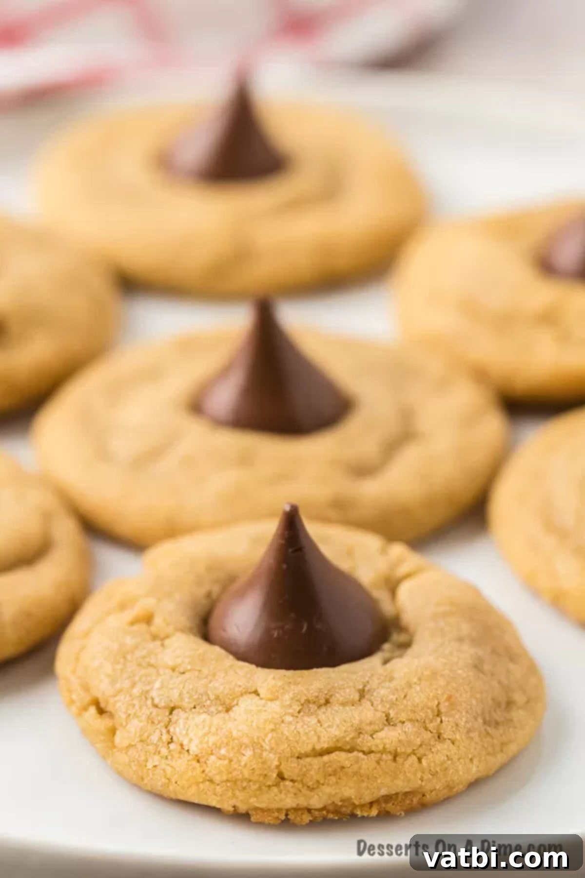 Chocolate-Kissed Peanut Butter Delights 2 Peanut butter kiss cookies on a platter, showcasing their perfect shape and chocolate tops.