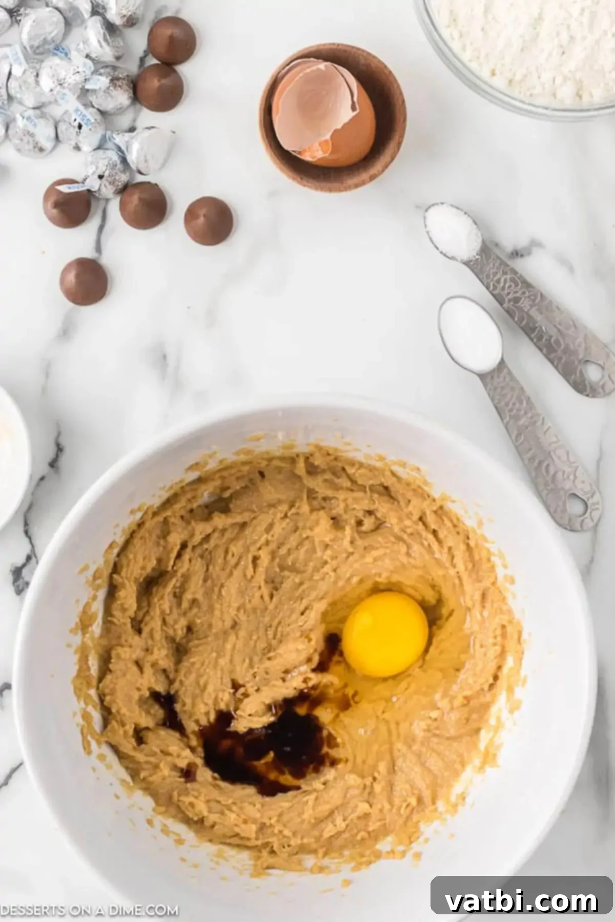 Chocolate-Kissed Peanut Butter Delights 4 Adding the egg and vanilla to the peanut butter mixture in the bowl.