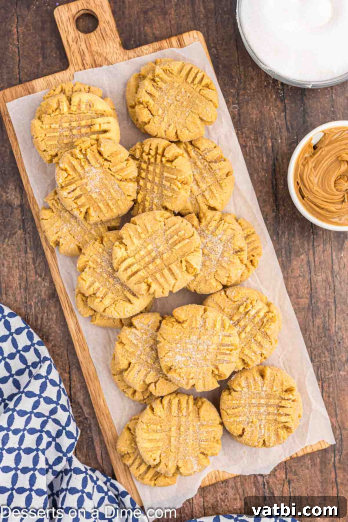 Peanut Butter Cake Mix Cookie Bliss 8 A selection of Peanut Butter Cake Mix Cookies neatly arranged on a wooden cutting board, showcasing their inviting texture and golden color.