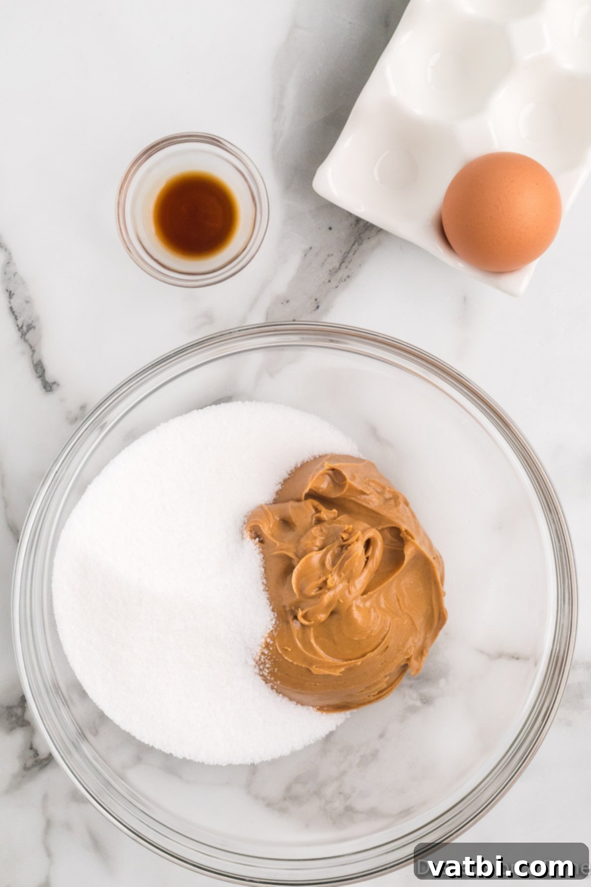 Mixing bowl with peanut butter, sugar and egg.