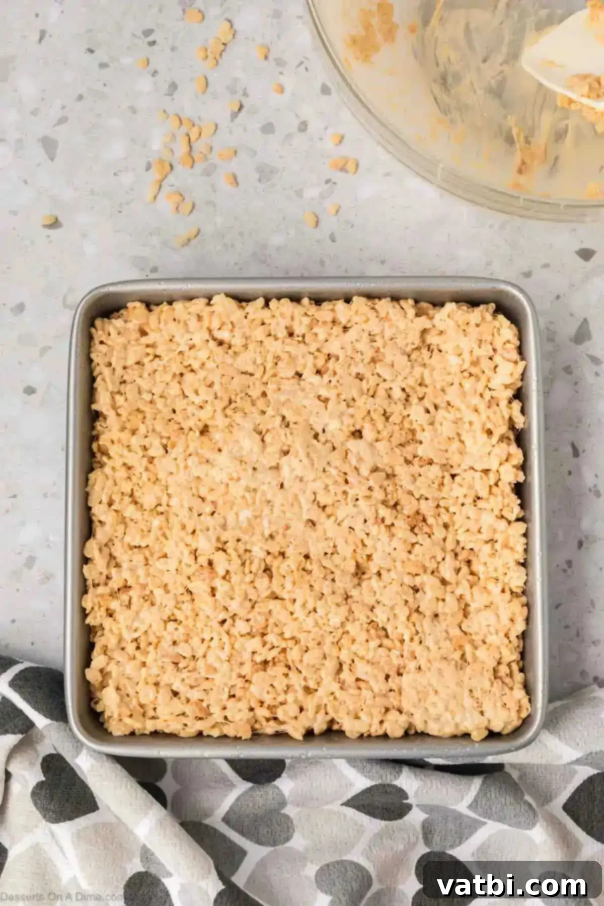 Irresistible Salted Caramel Rice Krispies 7 Cereal mixture pressed into baking dish.