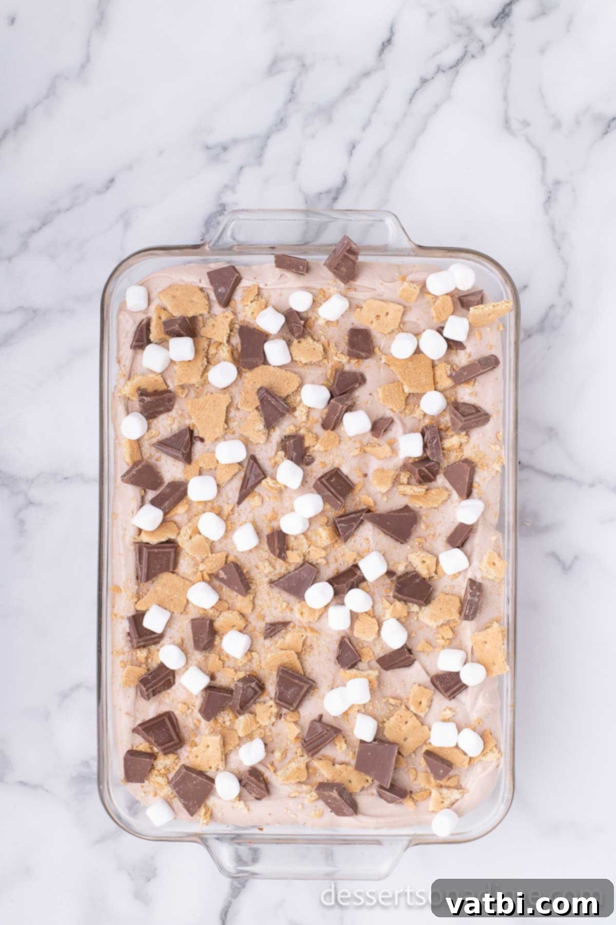 Graham crackers and chocolate on top of cake. 