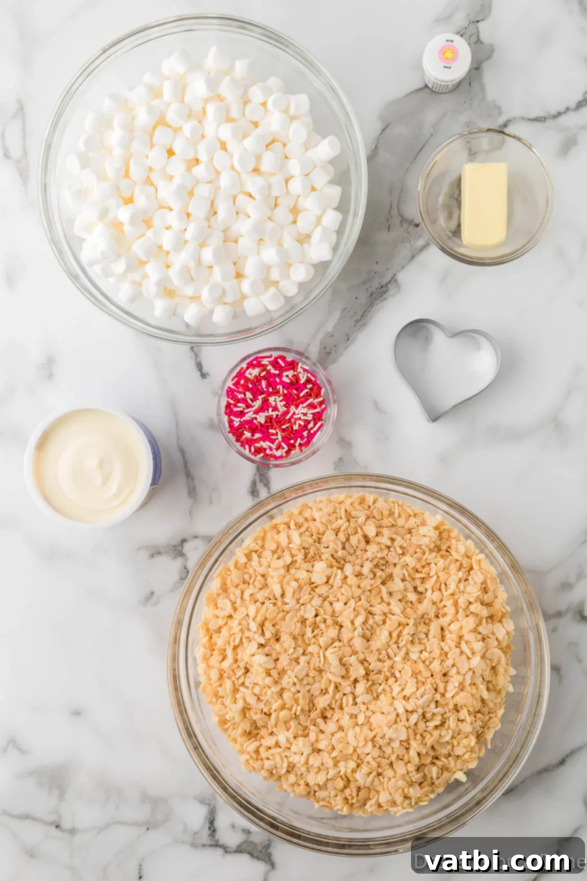 Ingredients for Valentine Rice Krispie Treats recipe - rice krispie cereal, mini marshmallows, red food coloring, vanilla frosting, and festive sprinkles.