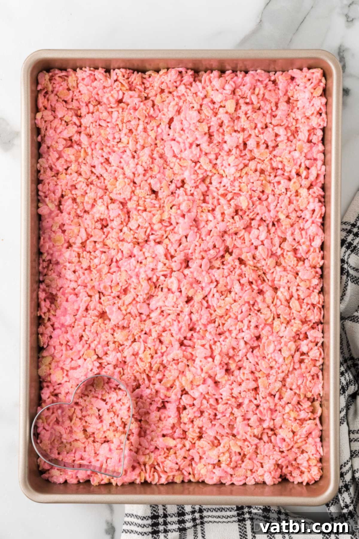 The Rice Krispie mixture spread evenly into a 9x13 baking pan, ready to set.