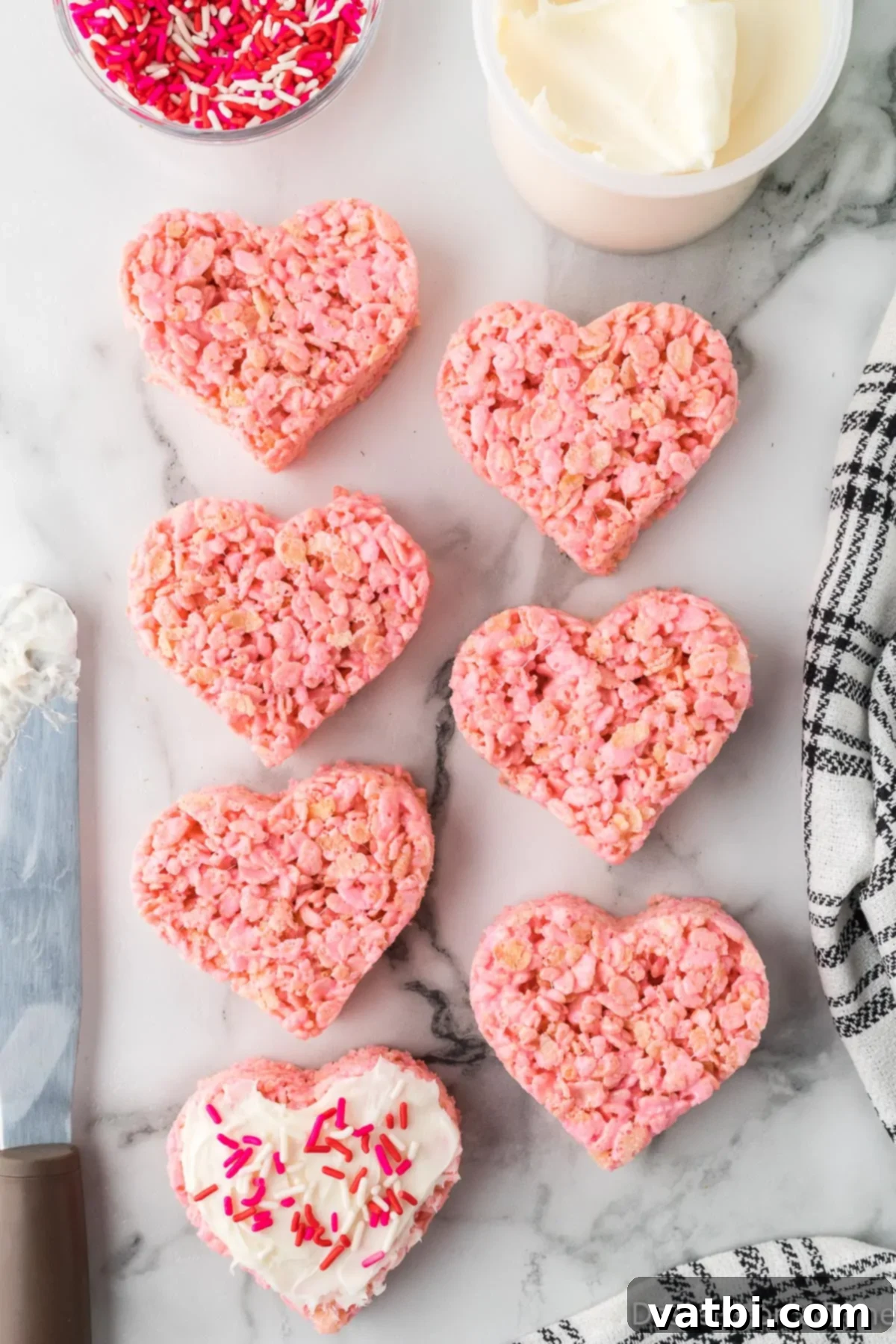 Heart-shaped Rice Krispie Treats with a smooth layer of vanilla frosting.