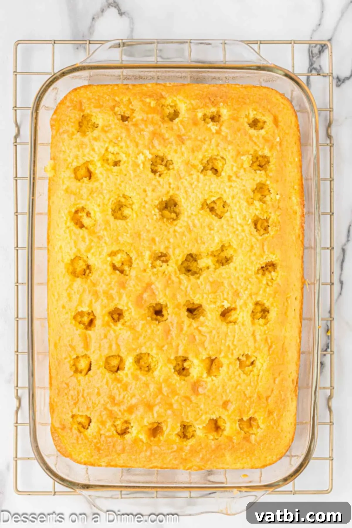 Tangy Lemon Infusion Cake 7 The liquid lemon jello mixture being gently poured over the poked holes of the warm cake.