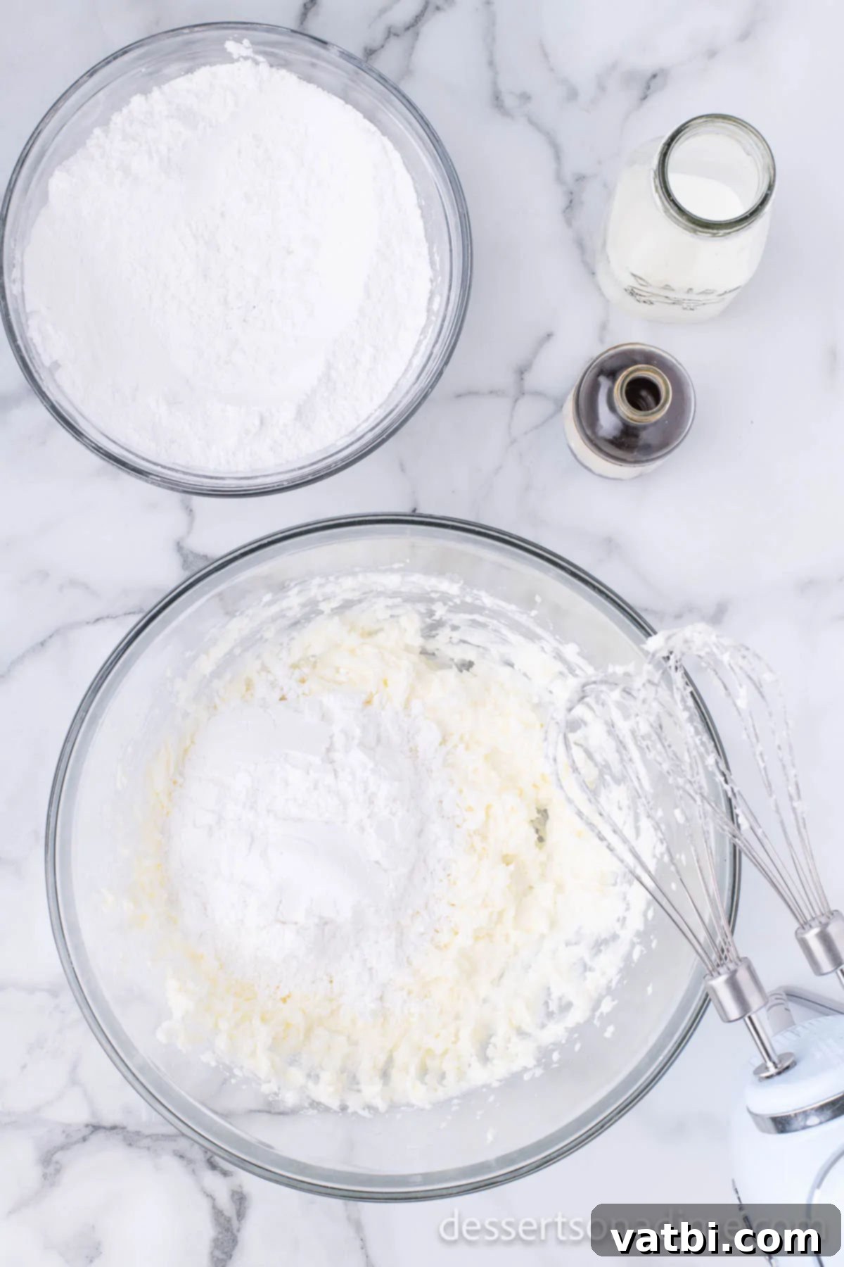Sifted powdered sugar being added gradually to the butter and shortening mixture in a mixing bowl.