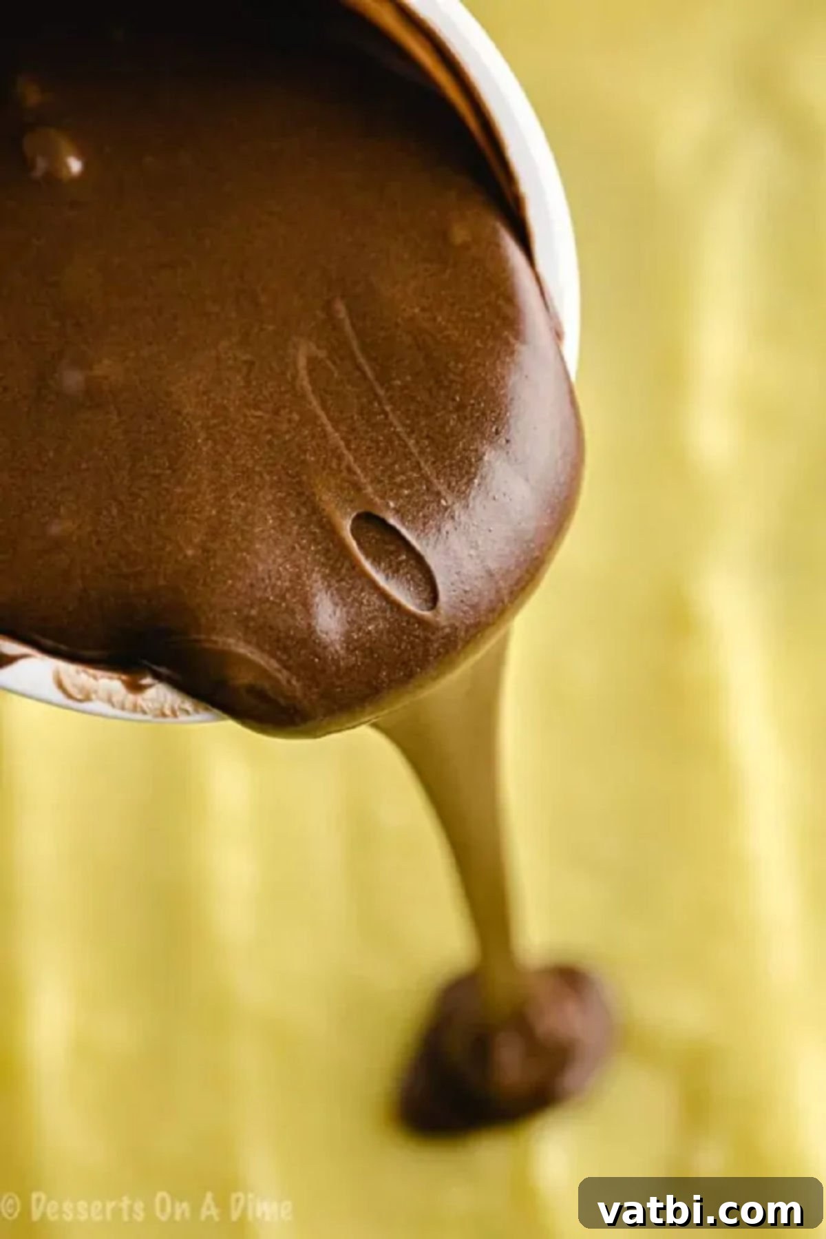 Boston Cream Poke Cake 3 Melted chocolate frosting being poured over the set pudding layer.