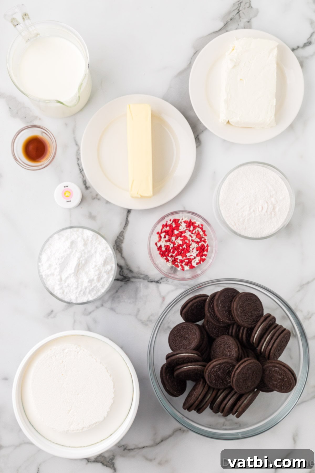 Ingredients for recipe - oreo cookies, cream cheese, butter, cool whip, vanilla pudding mix, pink food coloring and sprinkles. 