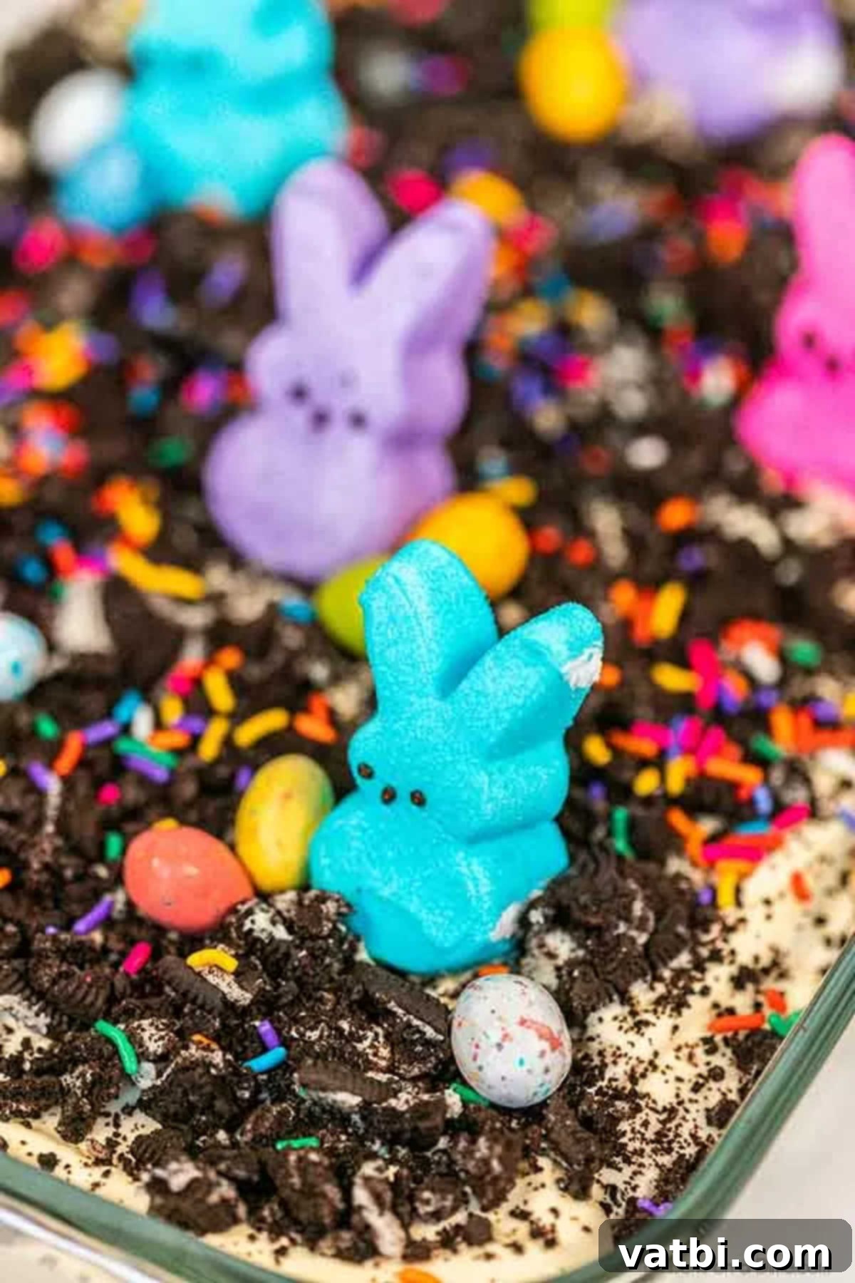Easter dirt cake is an easy and delicious no bake treat perfect for dessert on Easter. This fun dessert is decorated with Easter peeps, candy and more. The fully assembled and decorated Easter dirt cake in a pan, ready to be served at an Easter gathering.