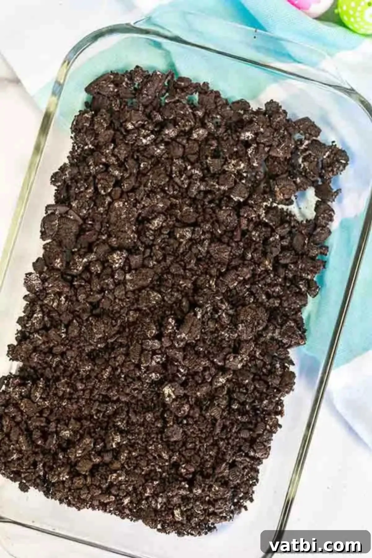 Hoppy Easter Dirt Delight 2 Crushed Oreo cookies evenly spread in the bottom of a 9x13 inch baking pan.