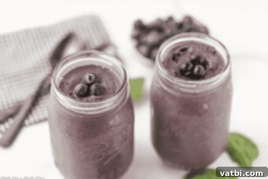 27 Deliciously Easy Blueberry Desserts 6 Two jars of blueberry smoothie with mint leaves.