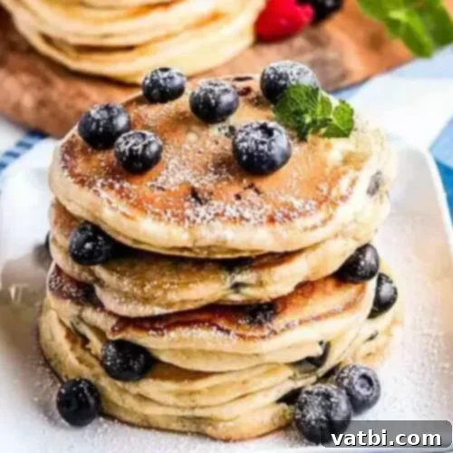 27 Deliciously Easy Blueberry Desserts 4 A stack of blueberry pancakes with fresh blueberries.