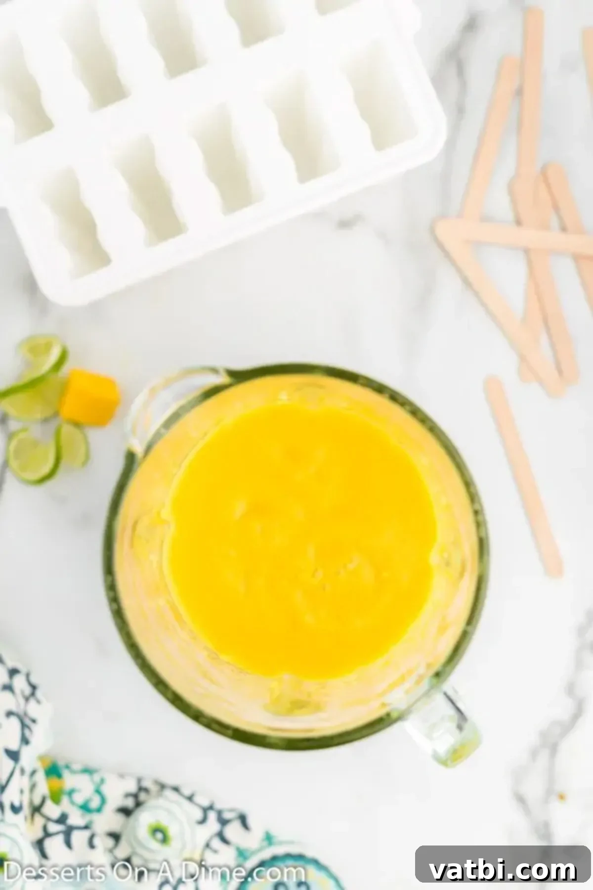 Sunshine Mango Freezies 4 Diced mango, water, honey, and lime juice being blended into a smooth puree in a food processor.