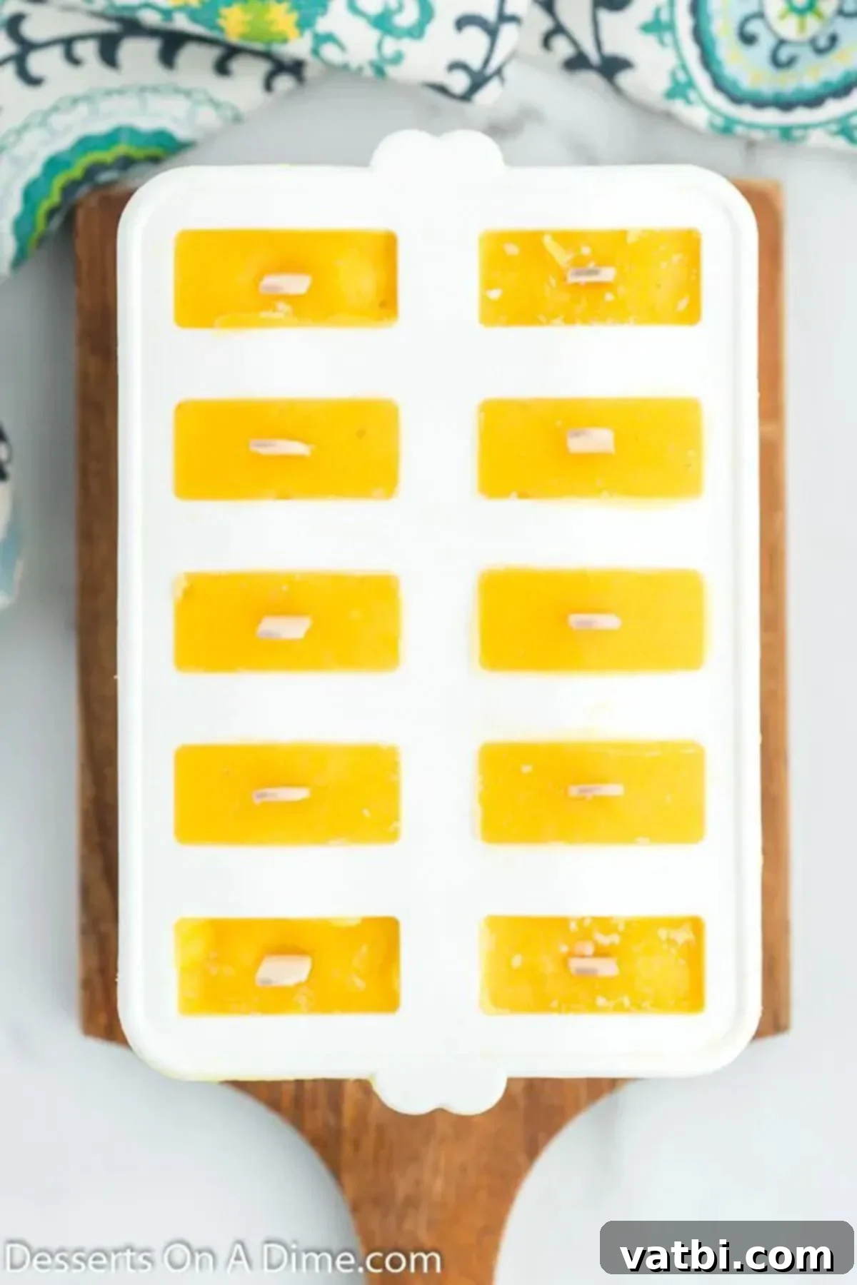 Sunshine Mango Freezies 6 Popsicle sticks carefully inserted into molds filled with mango mixture, ready to be placed in the freezer.