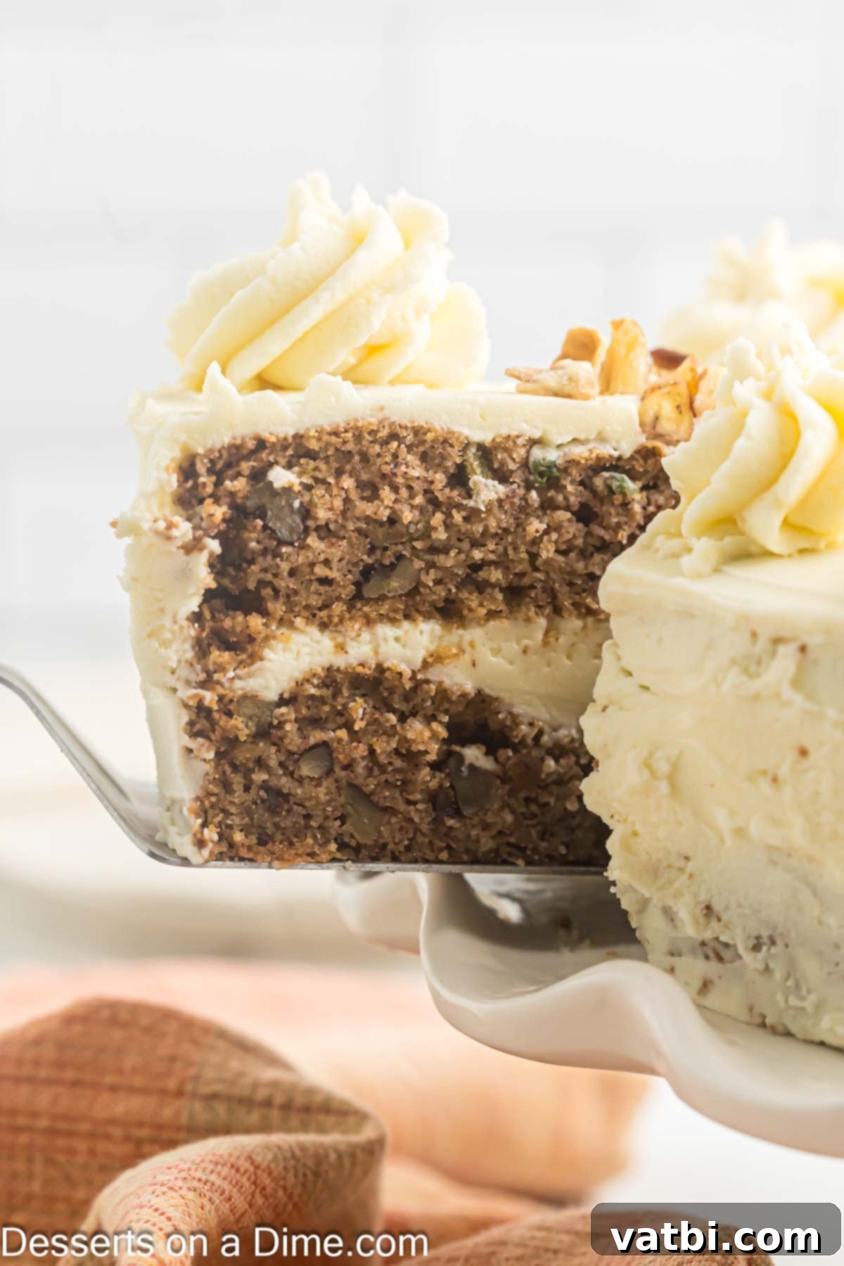 A perfectly sliced Keto Carrot Cake, revealing its moist layers and thick cream cheese frosting, ready to be enjoyed.