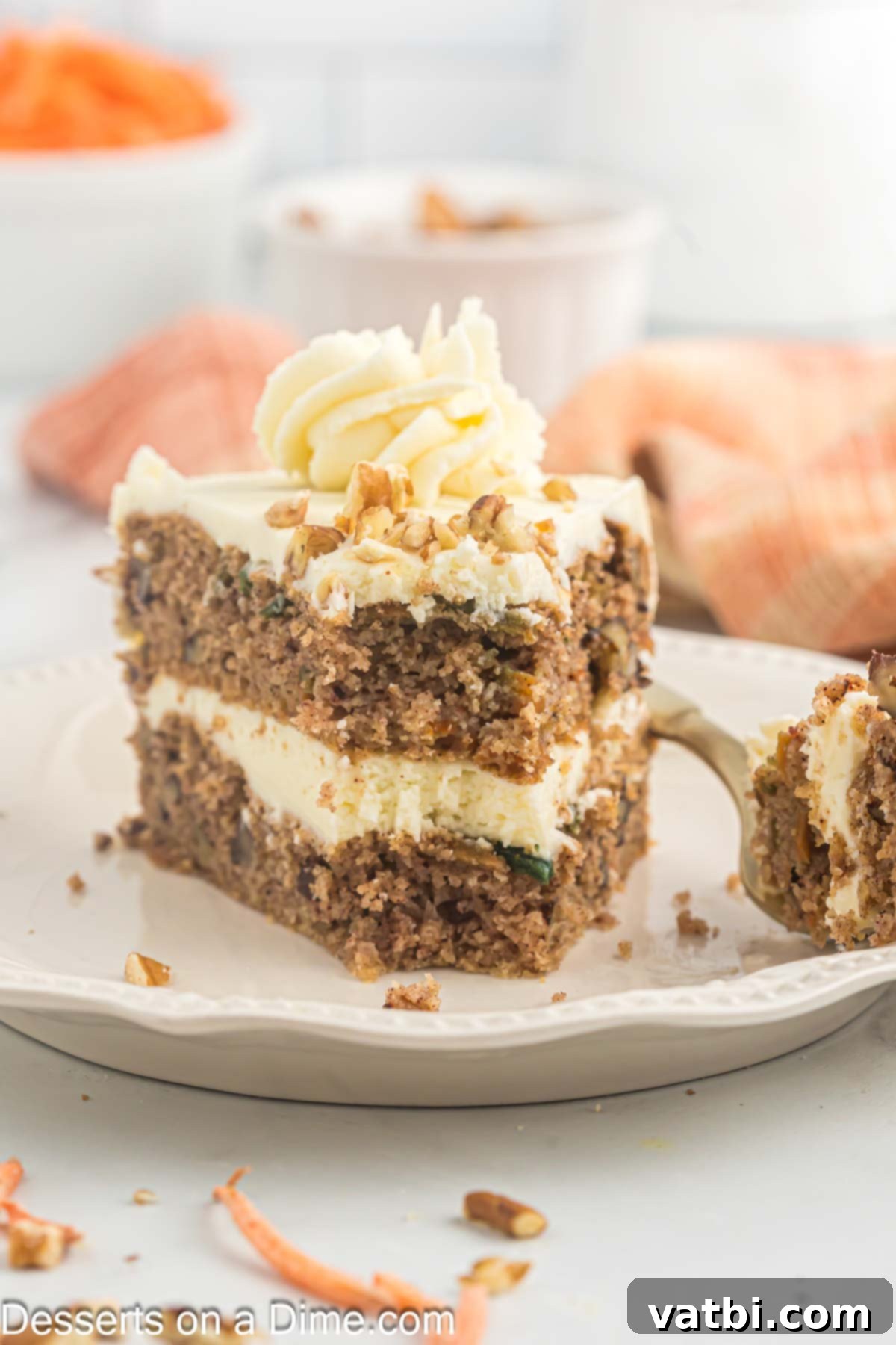 A single slice of moist Keto Carrot Cake, topped with thick cream cheese frosting and pecans, presented elegantly on a white plate.