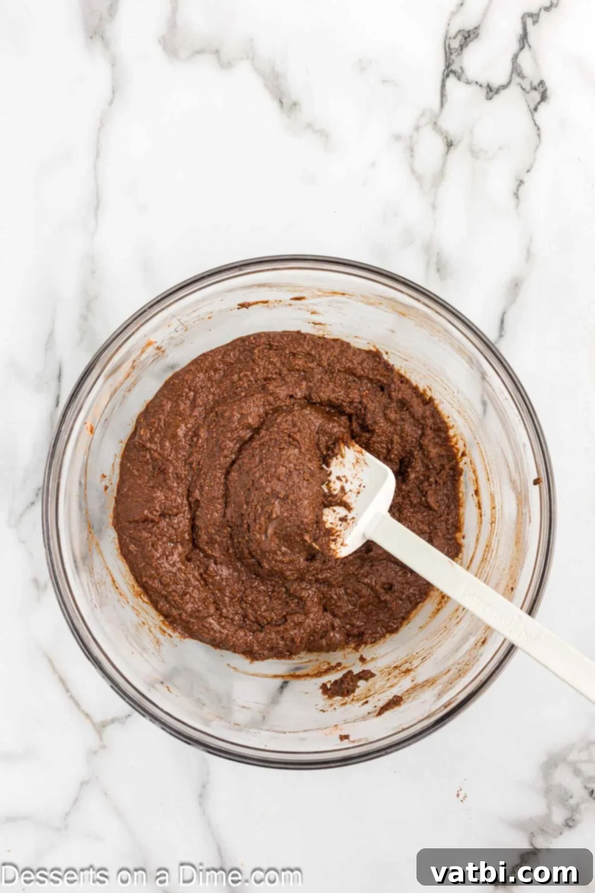 Decadent Keto Chocolate Delight 5 Close-up of fluffy, rich chocolate cake batter being mixed in a bowl, showcasing its smooth consistency and readiness for baking.