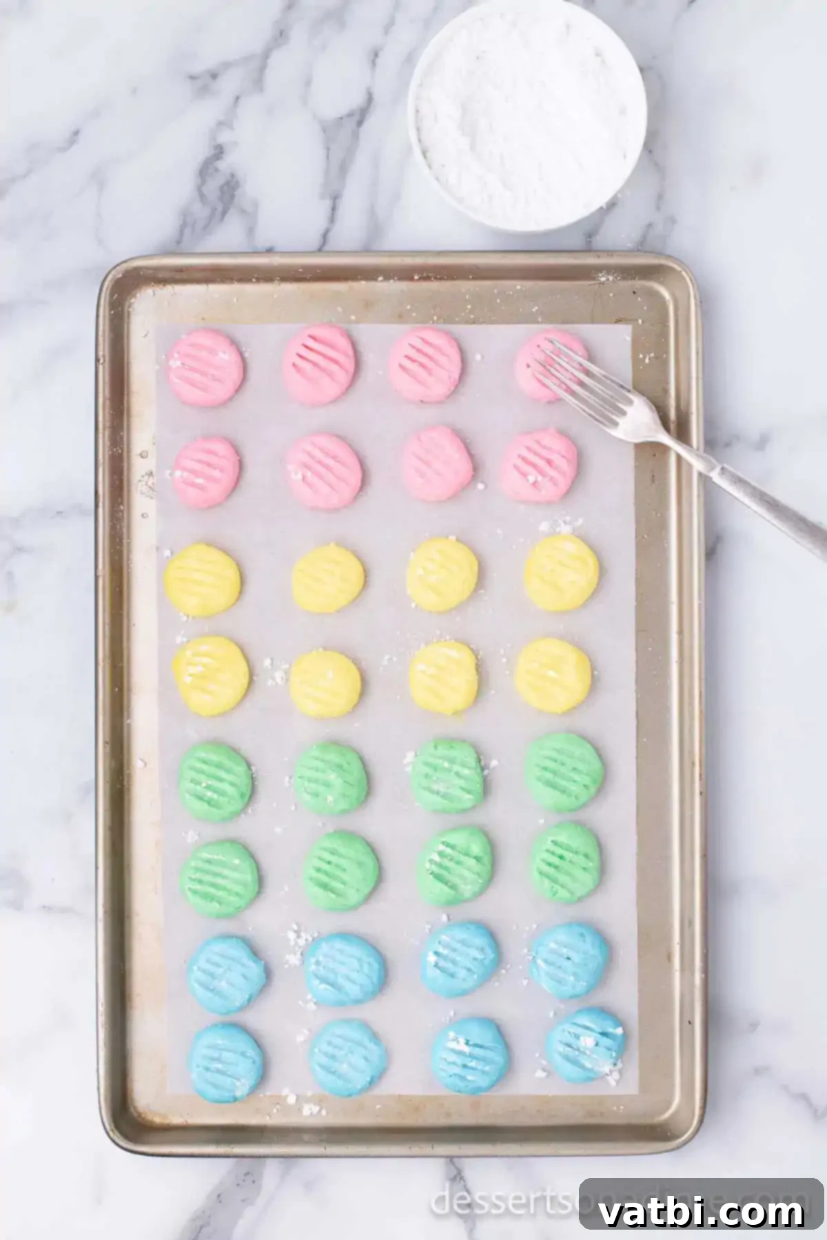 Mints on baking sheet with fork making design. 