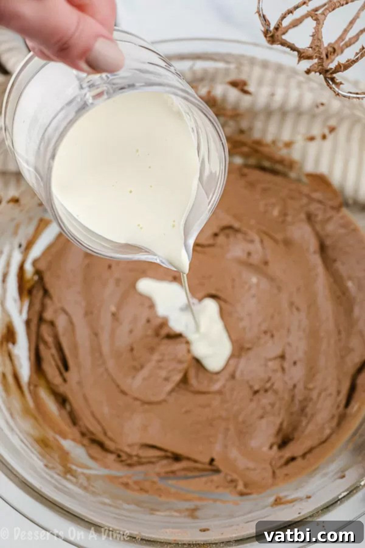 A visual step-by-step of preparing the keto chocolate frosting, showing heavy cream being slowly poured into the chocolate mixture.