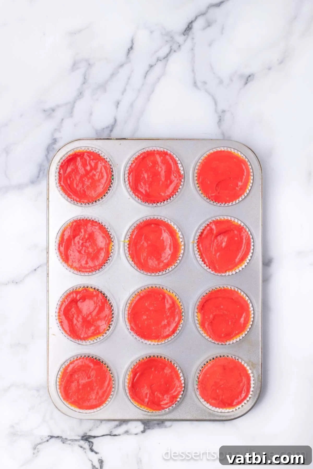 Spectrum Sweets 6 Batter piped into layers in each cupcake liner.