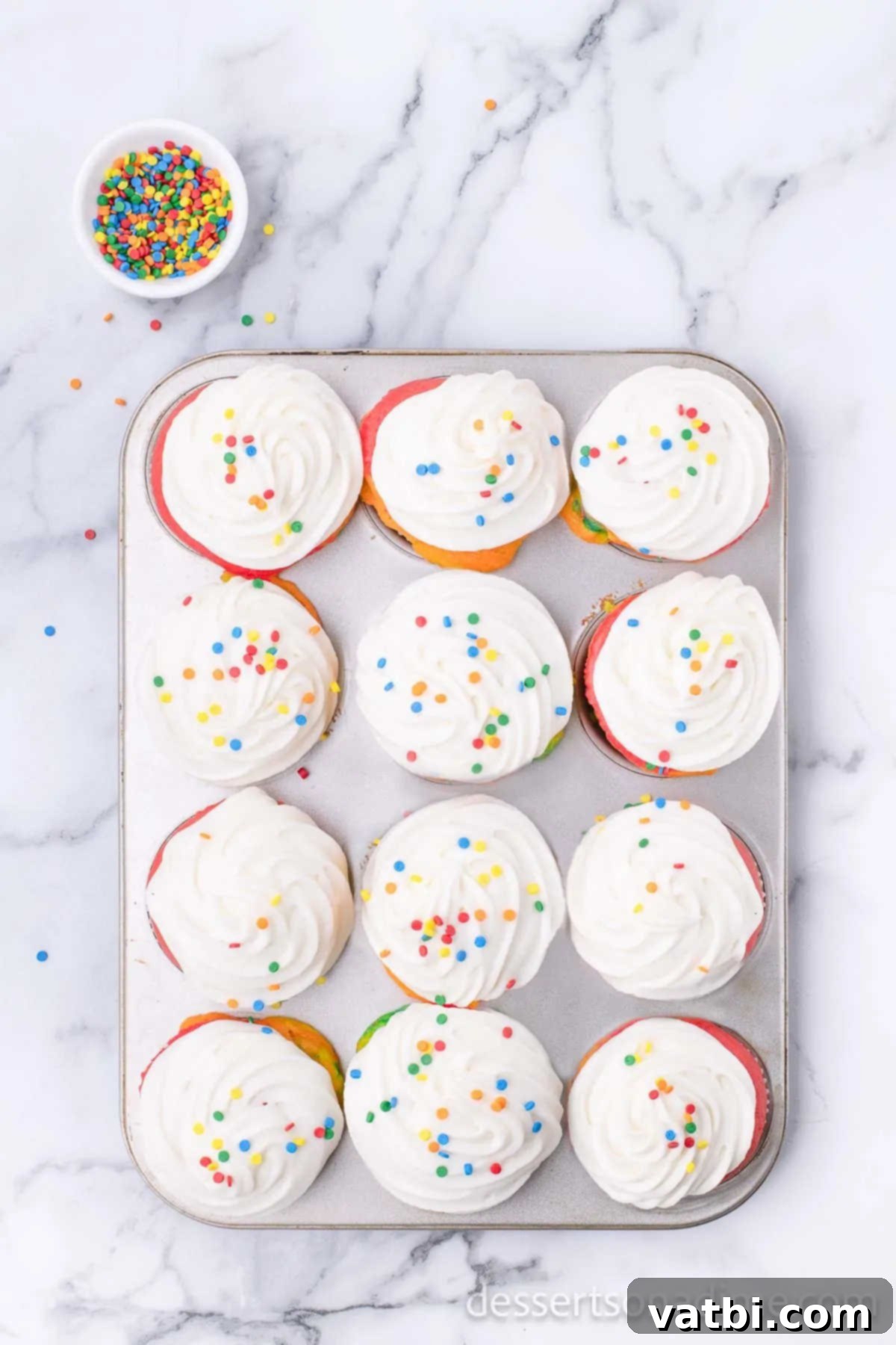 Spectrum Sweets 9 Cupcakes topped with frosting and sprinkles.