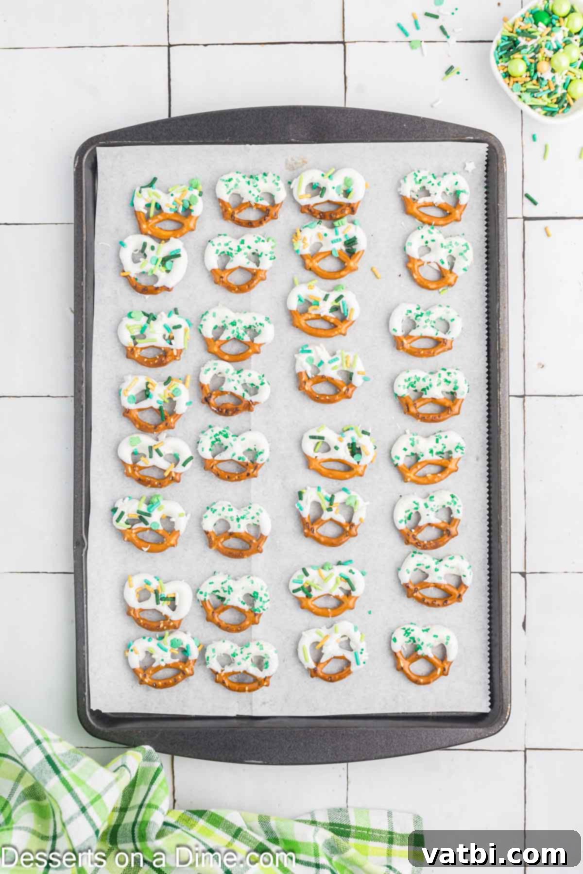 Pretzels drying on a baking sheet lined with wax paper. 