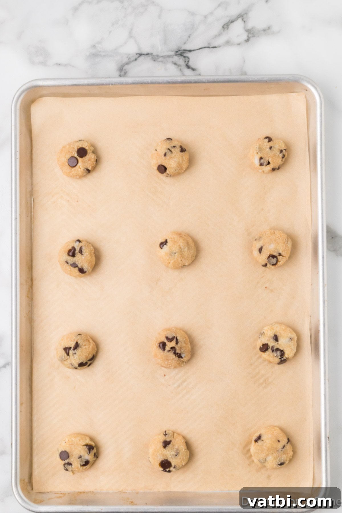 Guilt-Free Keto Chocolate Chip Delights 5 Scooping cookie dough onto a baking sheet for keto chocolate chip cookies.