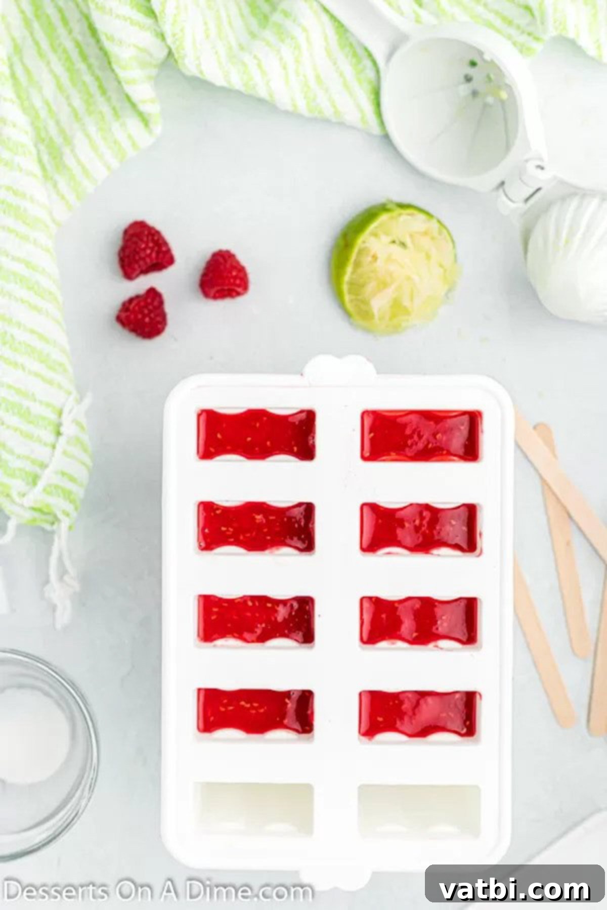Homemade Raspberry Bliss Pops 5 Raspberry popsicle mixture being poured into molds.