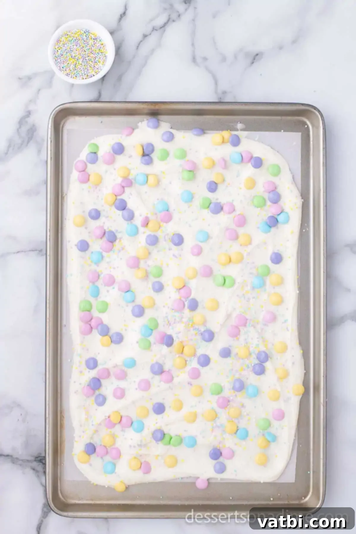 Delightful White Chocolate Easter Bark 6 Candy sprinkled on top of melted candy.