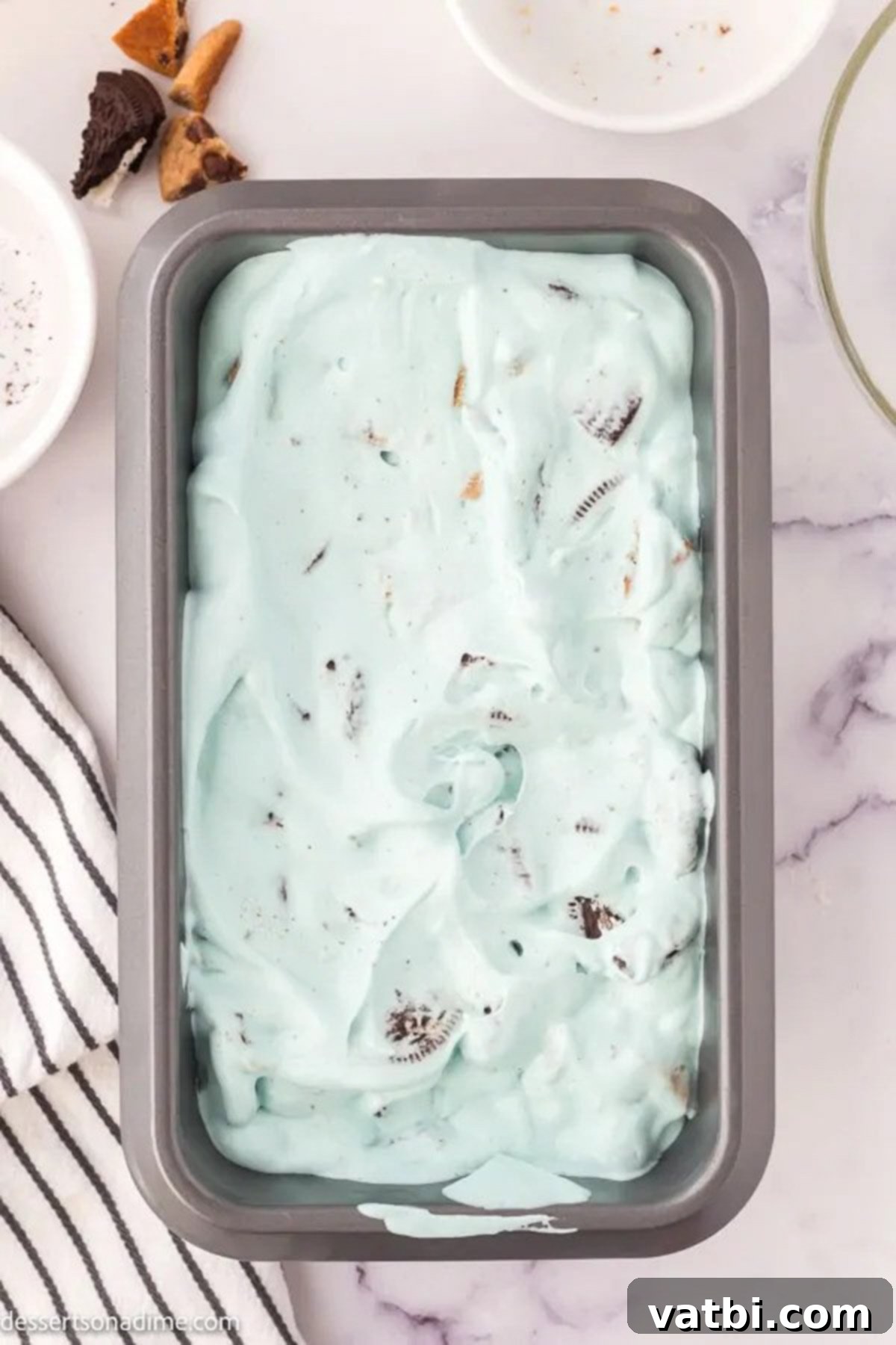 The Cookie Monster ice cream mixture evenly spread into a loaf pan, ready for freezing.