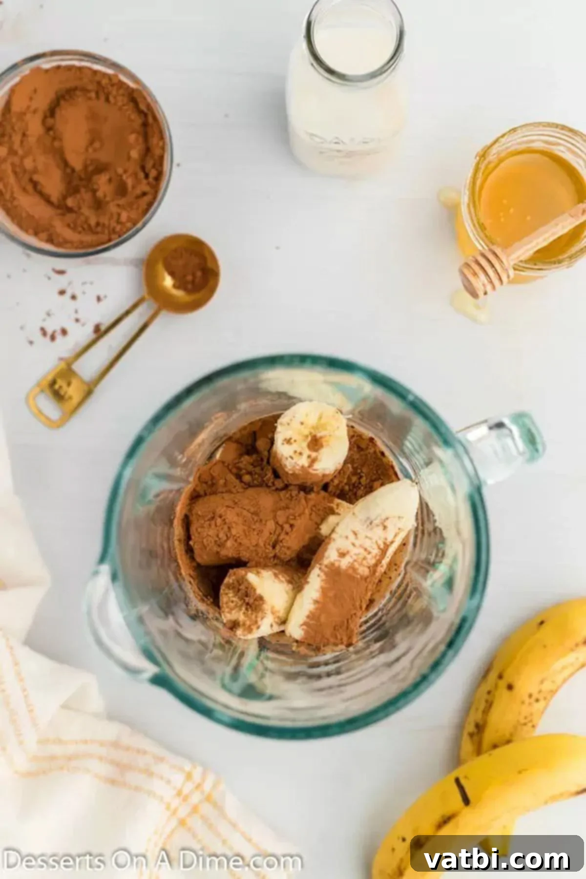 Ultimate Chocolate Banana Pops 4 Almond milk, bananas, cocoa powder, and honey in a blender, ready to be processed.