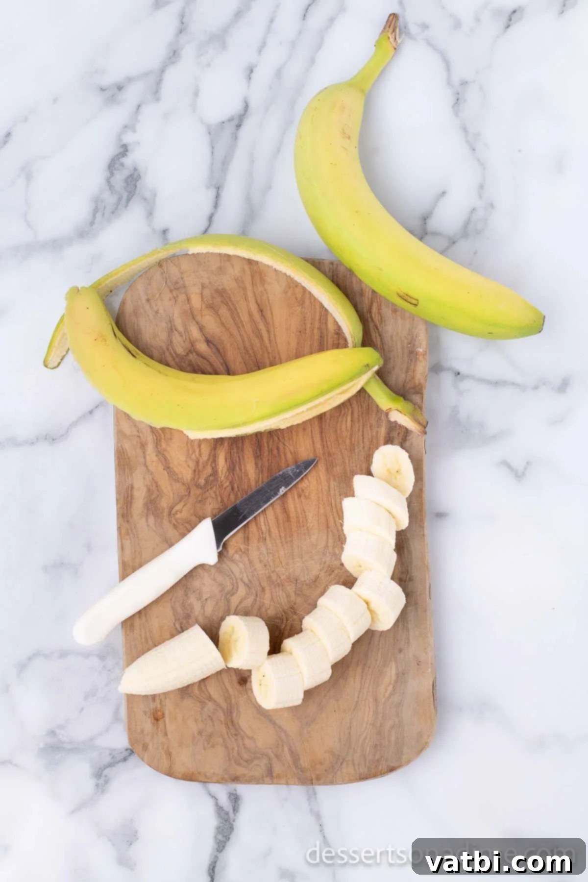 Sweet Golden Banana Bites 4 Sliced firm bananas on a wooden cutting board, ready for frying.