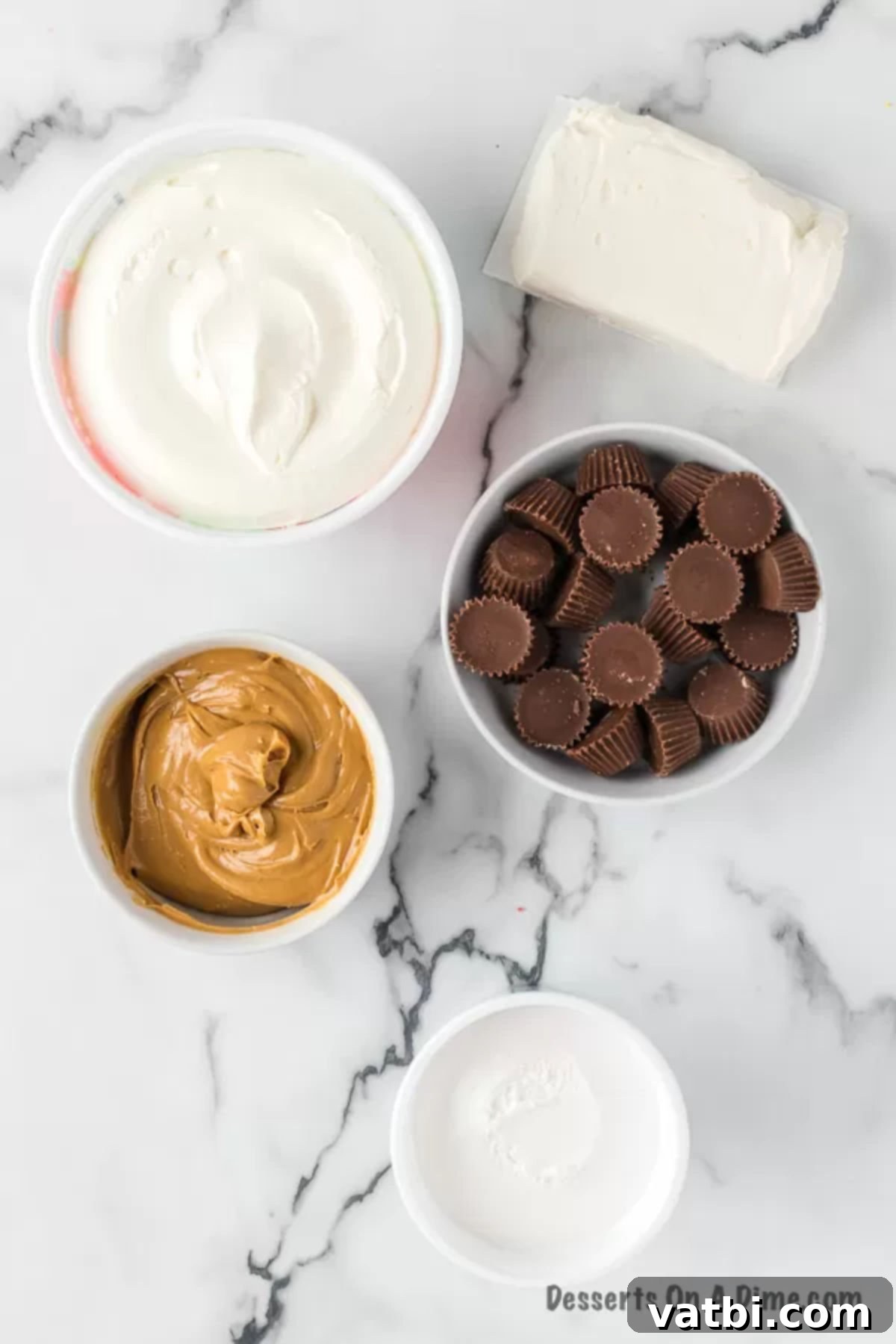 Whipped Peanut Butter Delight 3 Essential ingredients laid out for peanut butter fluff: cream cheese, creamy peanut butter, marshmallow creme, and miniature Reese's Peanut Butter Cups.