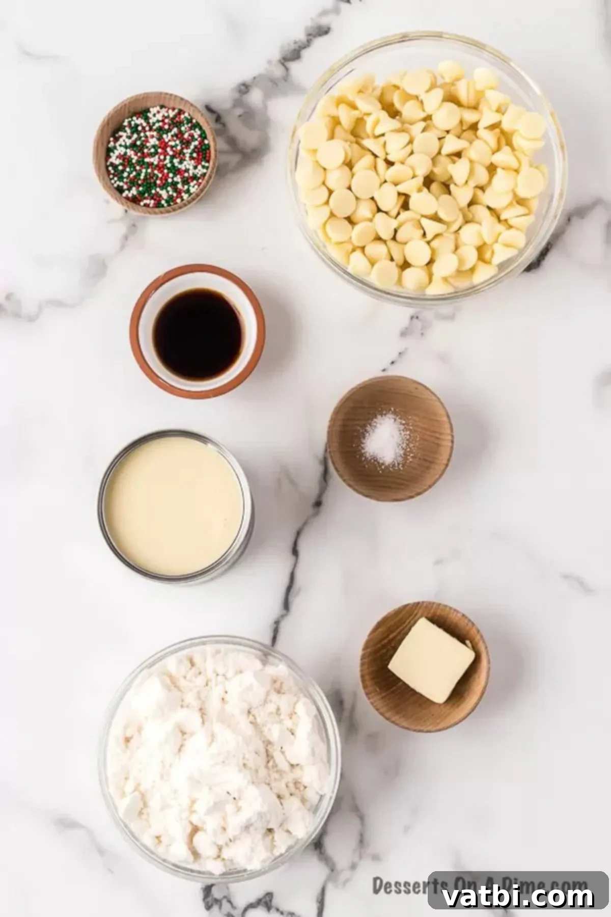 Ultimate Sugar Cookie Fudge 3 Ingredients for Sugar cookie fudge laid out: white chocolate chips, a can of sweetened condensed milk, sugar cookie mix, butter, vanilla extract, and a bowl of red, green, and white sprinkles.