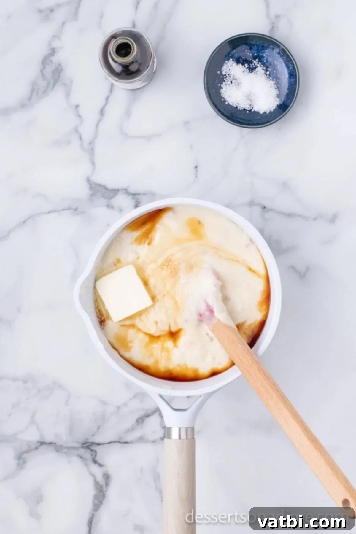 Ultimate Sugar Cookie Fudge 4 Sweetened condensed milk warming in a small saucepan over medium-high heat, being stirred.