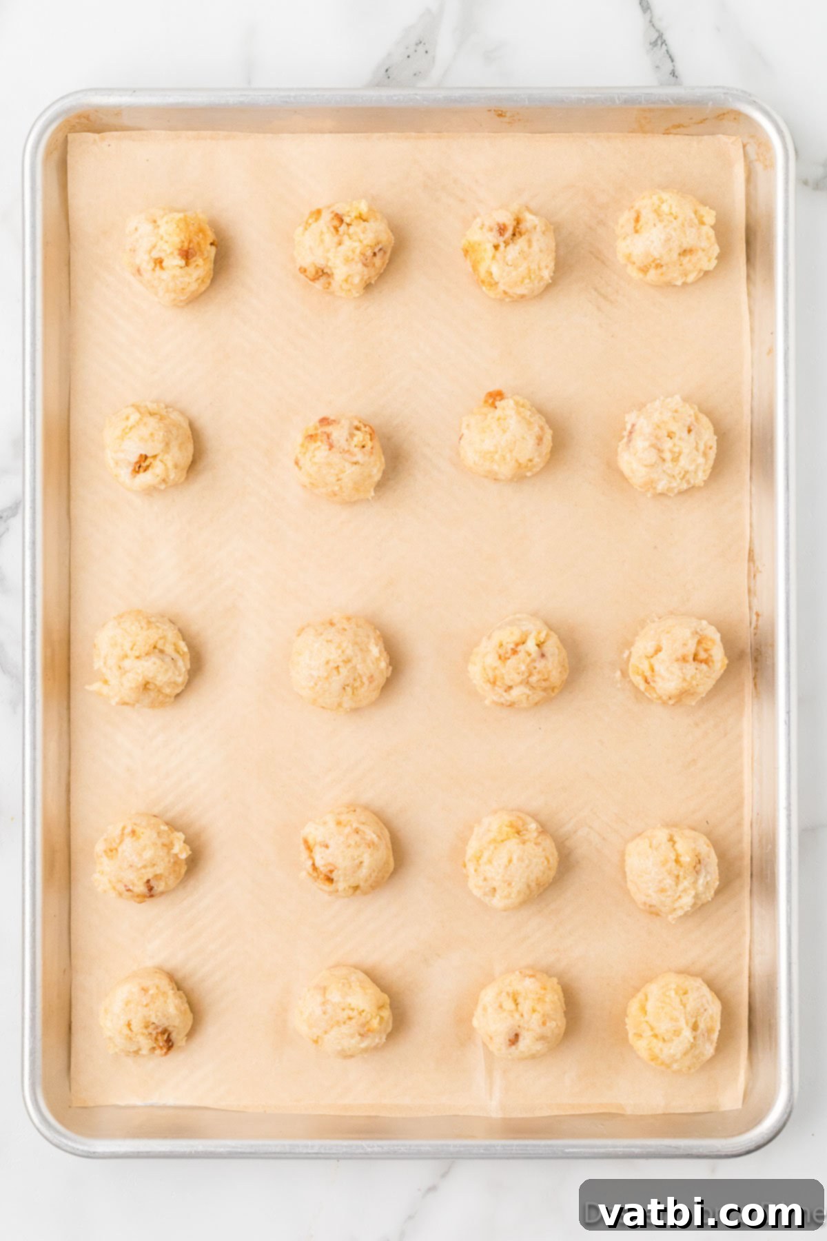 Homemade Vanilla Cake Delights 5 Rolled cake dough formed into uniform balls and placed on a baking sheet.