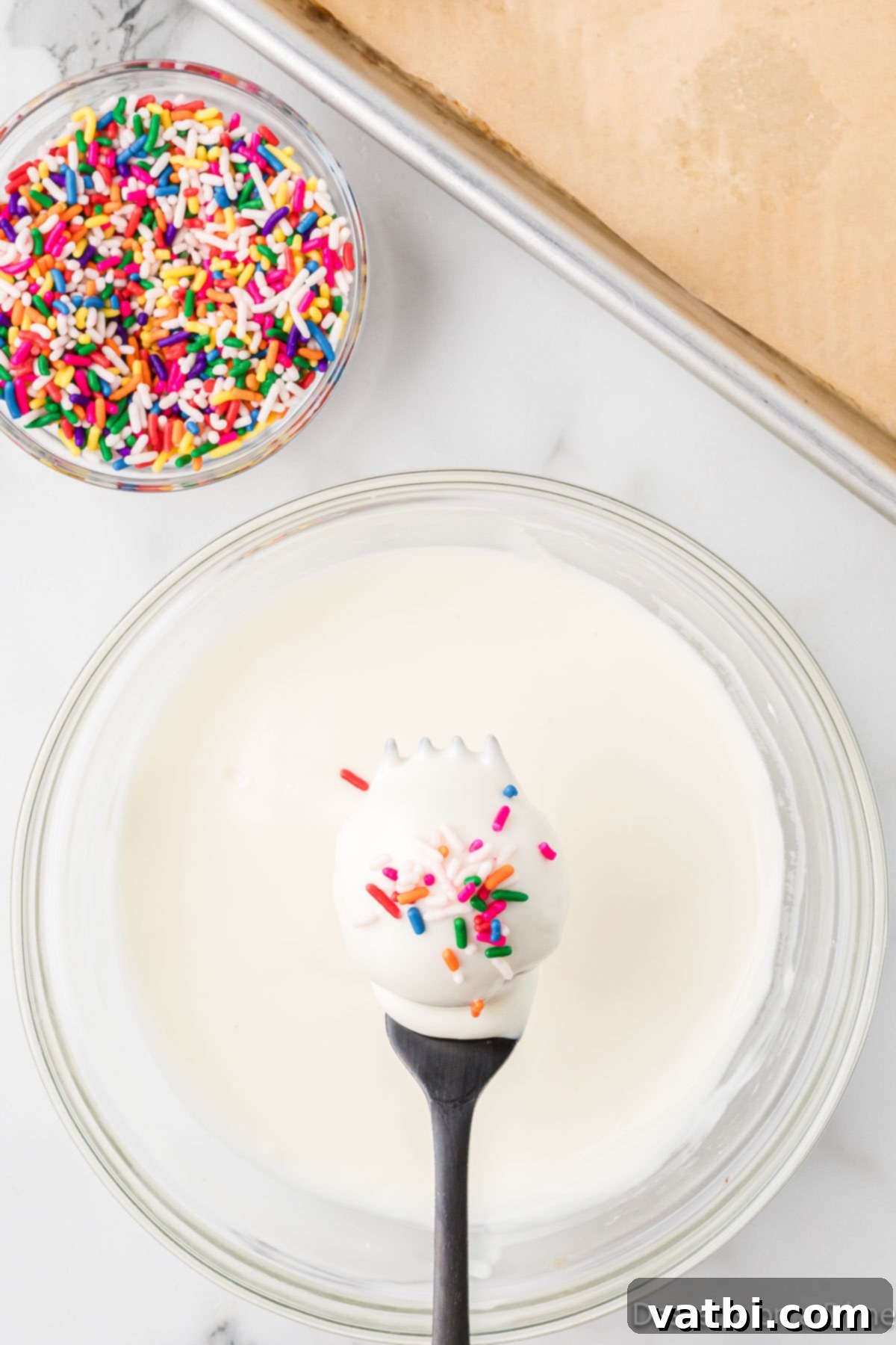 Homemade Vanilla Cake Delights 8 Colorful sprinkles being added to freshly dipped vanilla cake balls.