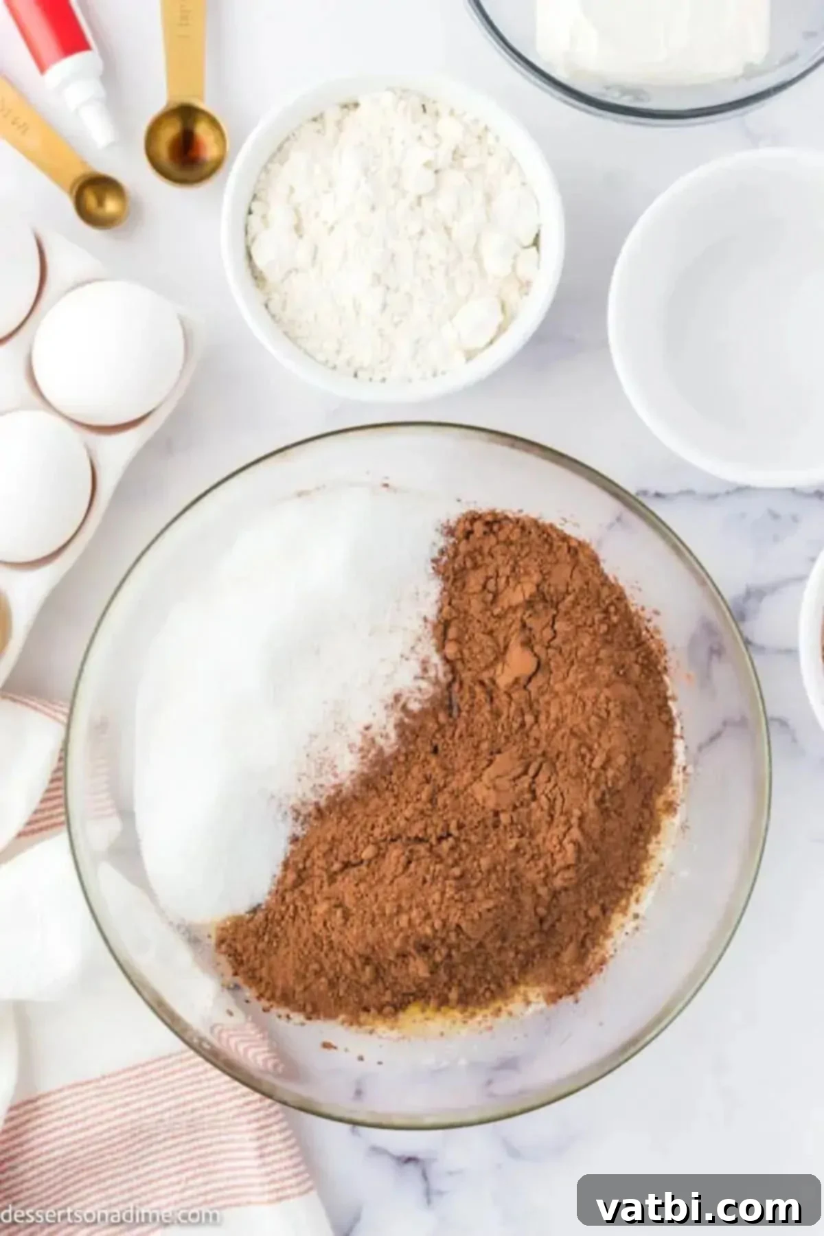Bowl of sugar, vanilla, and cocoa powder ready to be mixed for brownie batter.