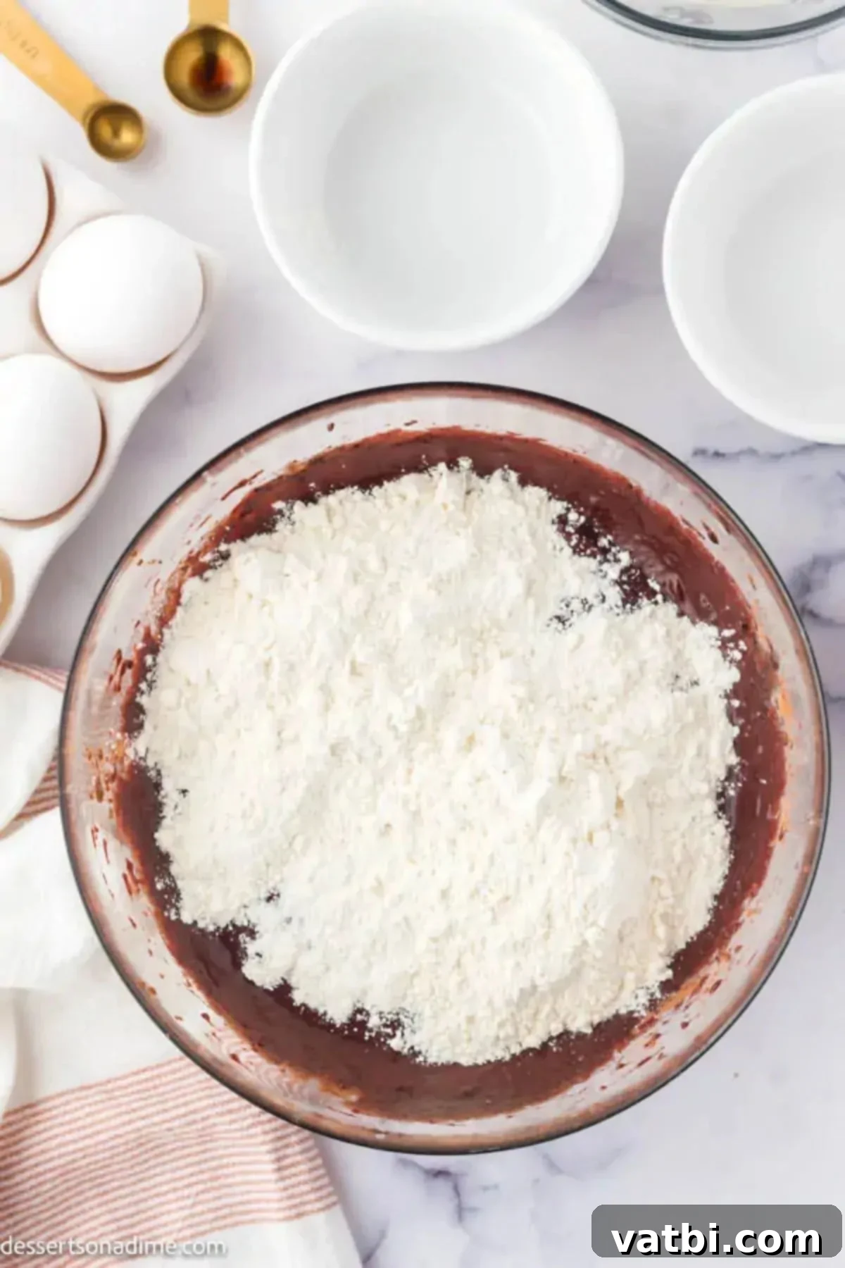 Wet and dry ingredients combined in a bowl, showing the red velvet brownie batter.