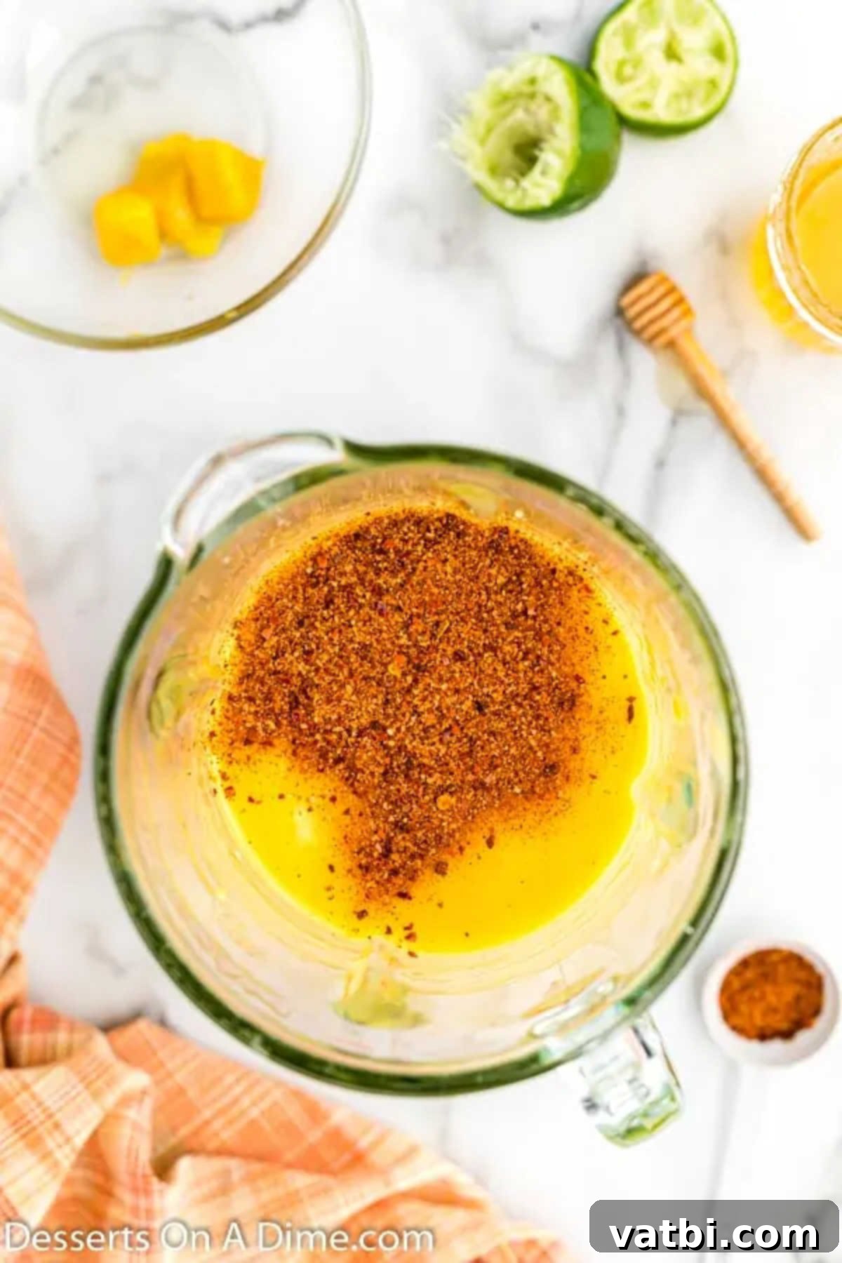Zesty Mango Tajin Popsicles 6 Tajin seasoning being added to the blended mango mixture in a blender, ready to be stirred in.