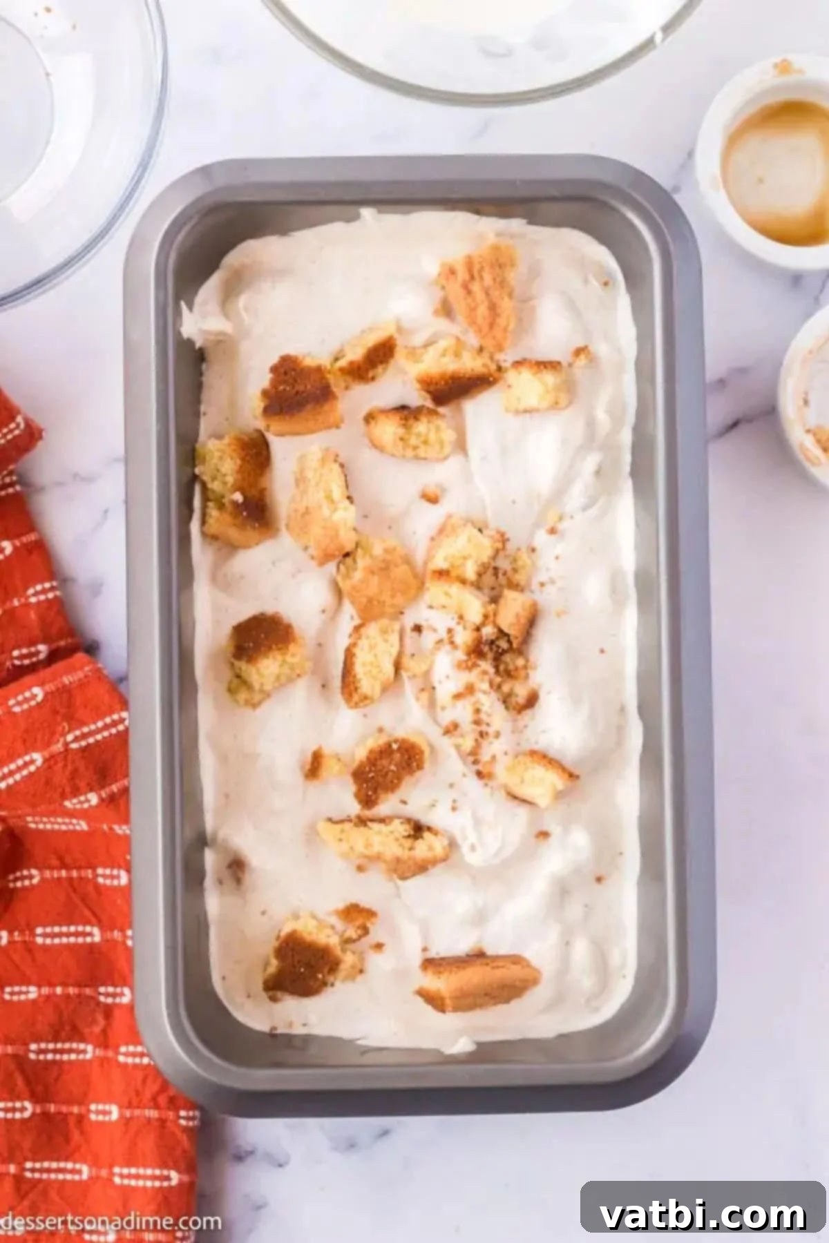 Snickerdoodle Cinnamon Swirl Ice Cream 7 The snickerdoodle ice cream mixture spread into a loaf pan, topped with extra cookie crumbs, ready for freezing.