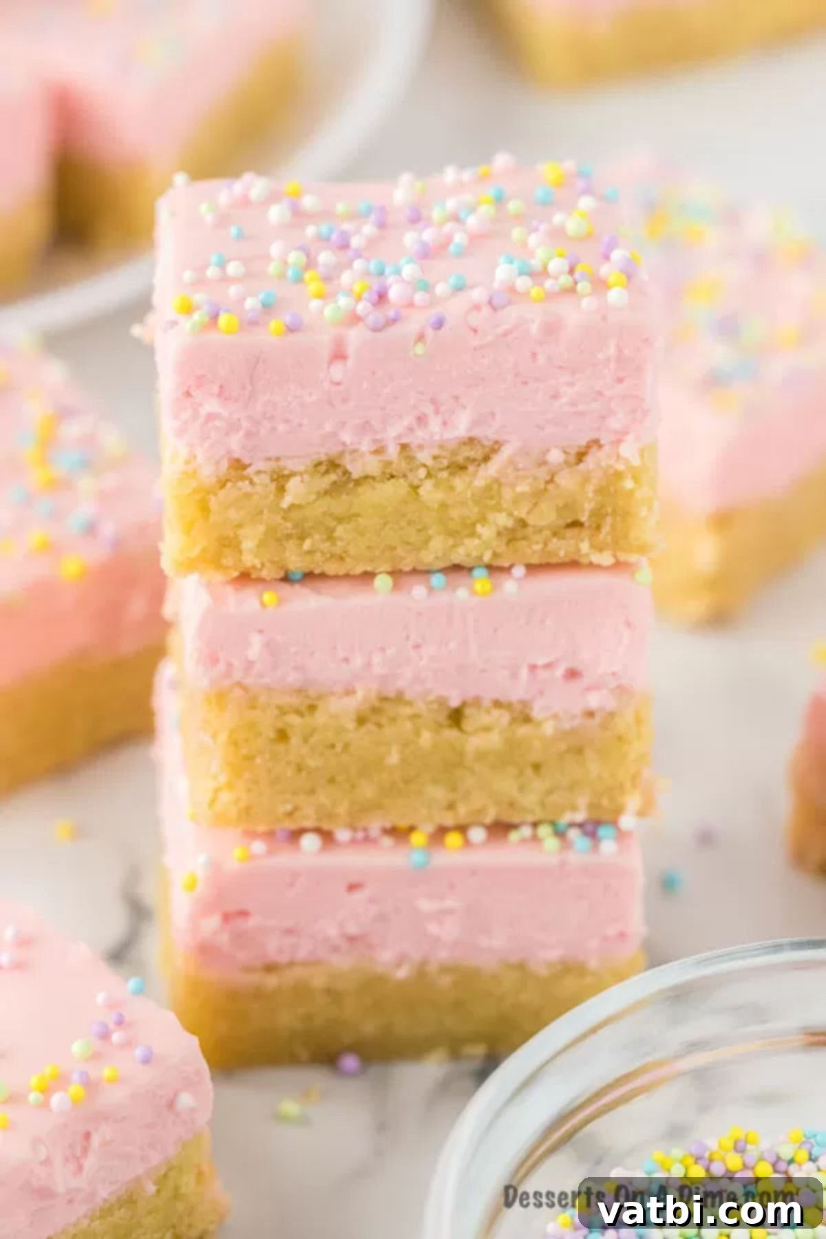 Homemade Sugar Cookie Squares 2 Sugar cookie bars stacked together, showing their thick, frosted layers and colorful sprinkles.