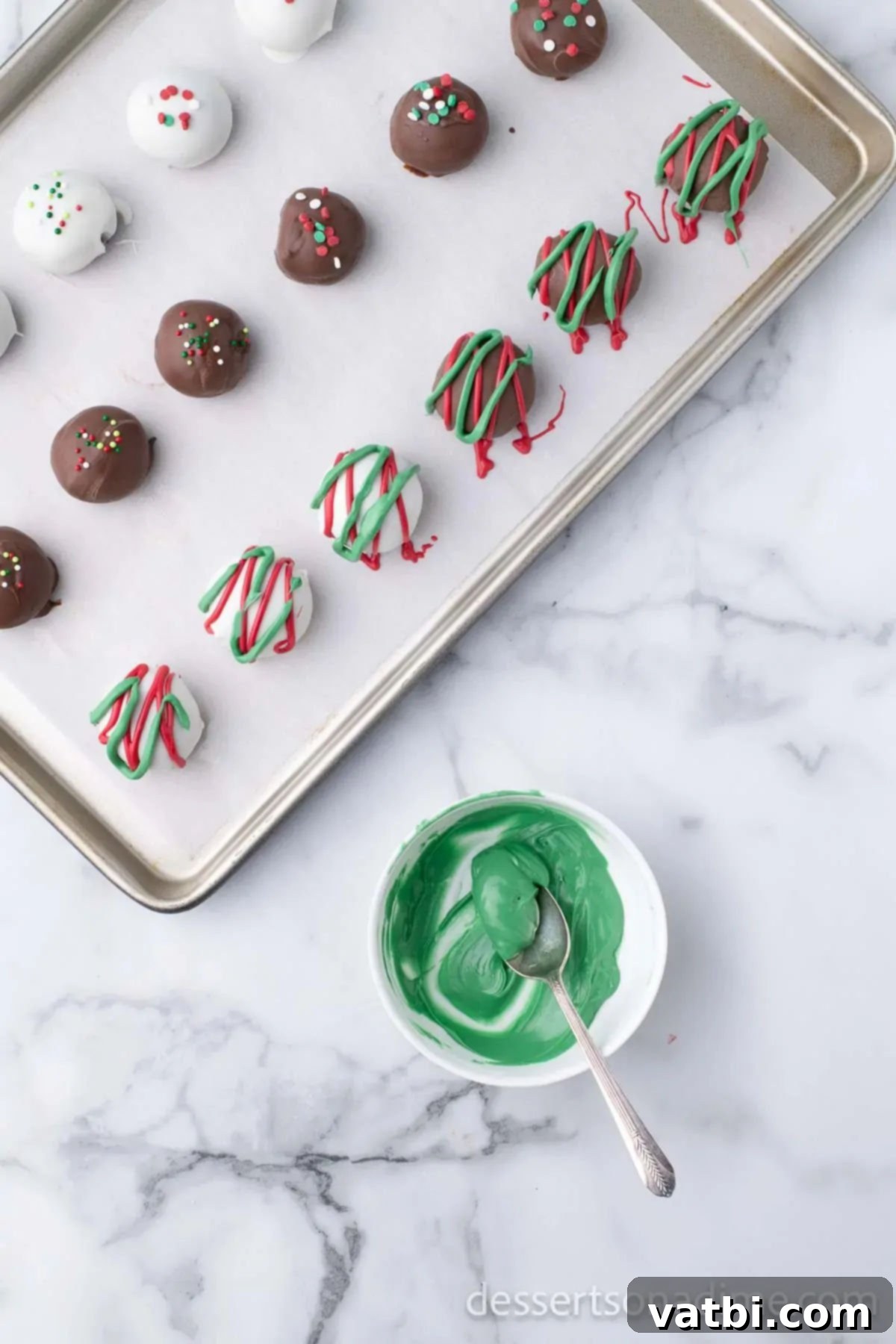 Easy Christmas Oreo Balls 12 Red and green candy melts artfully drizzled on Oreo truffles, creating a festive pattern.