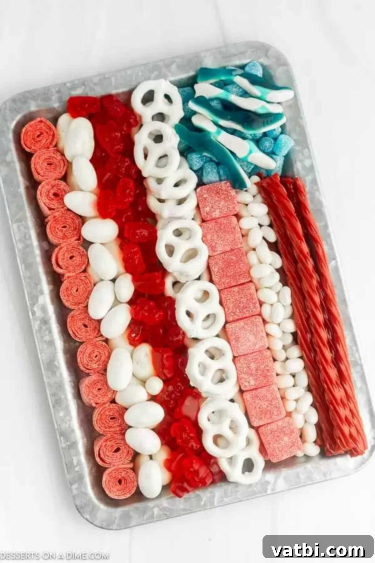 Star Spangled Sweet Treat Board 2 An American flag candy charcuterie board arranged on a rectangular tray, featuring rows of red and white candies and a blue square with white candies representing stars.