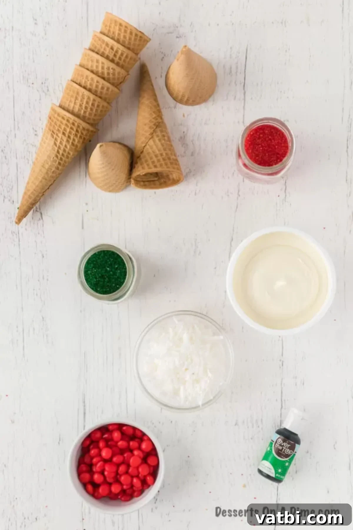 Sweet Ice Cream Cone Christmas Trees 3 A collection of ingredients needed for making Ice Cream Cone Christmas Trees, including frosting, food coloring, cones, and assorted candies.