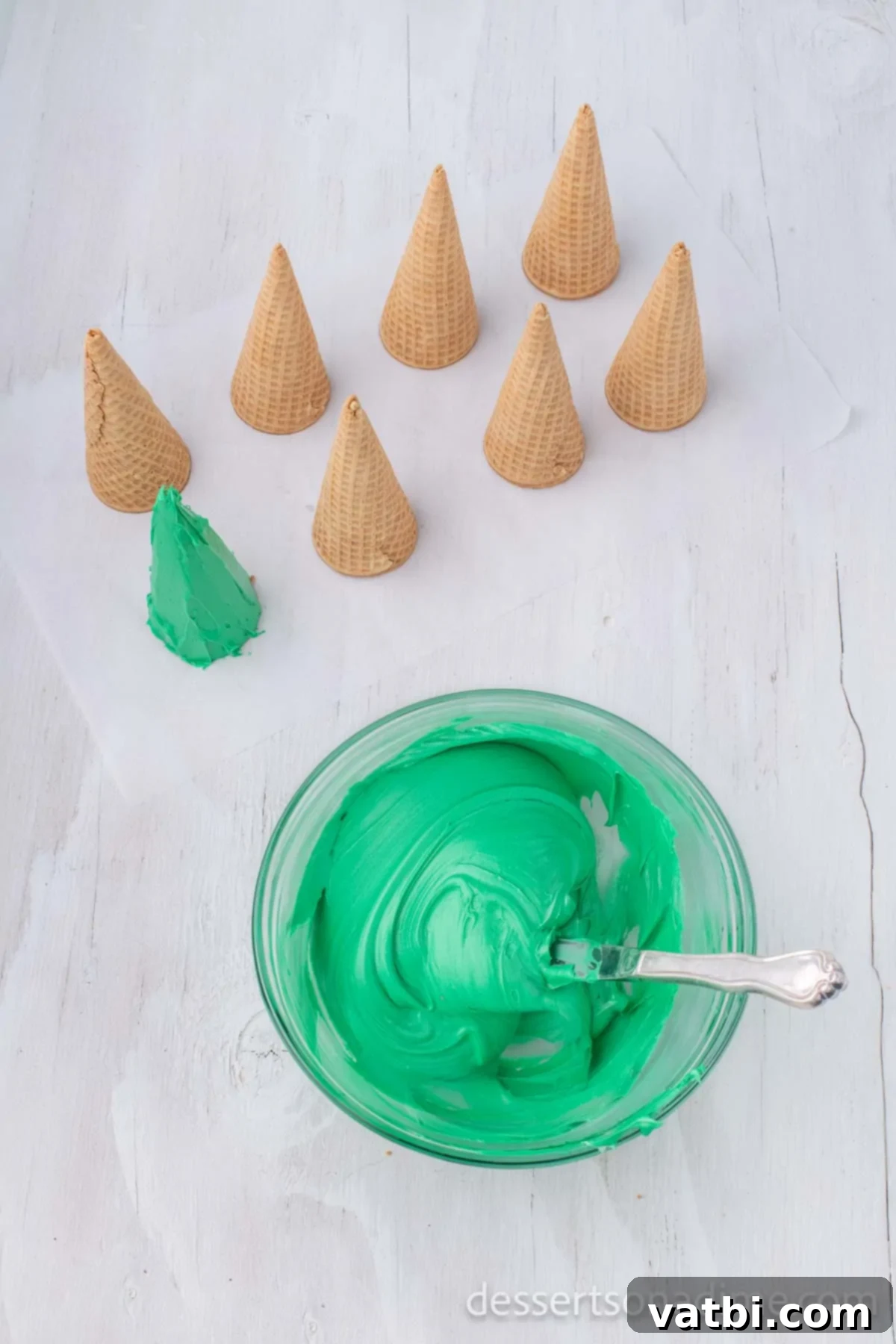 Sweet Ice Cream Cone Christmas Trees 5 Green food coloring thoroughly mixed into white frosting in a bowl, ready for decorating.