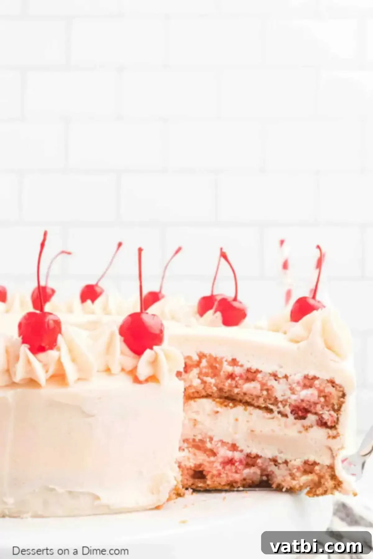 Perfect Cherry Chip Cake 2 A beautifully frosted Cherry Chip Cake with vibrant pink buttercream and whole cherries on top.