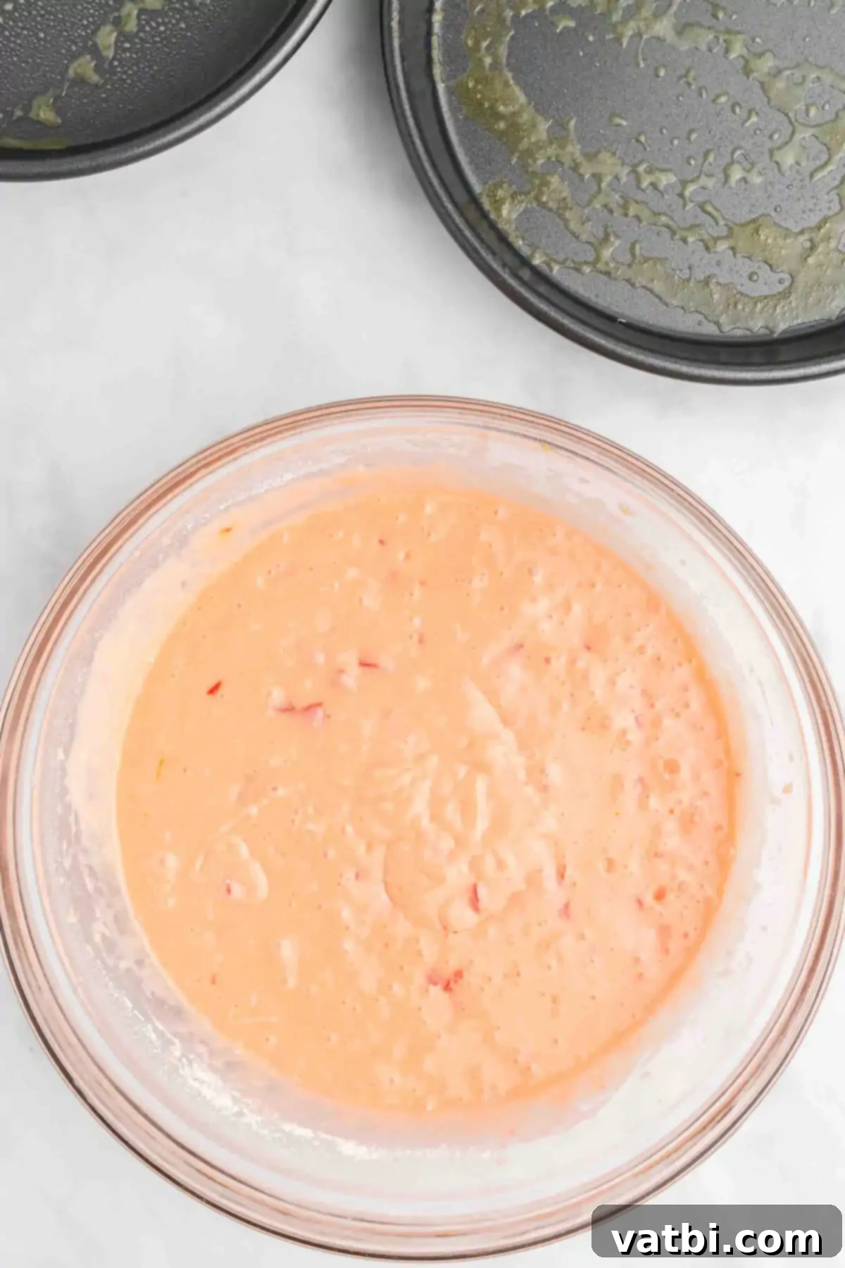Perfect Cherry Chip Cake 7 Wet and dry ingredients fully combined in a mixing bowl, creating a pink cake batter.